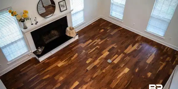 Image 4: Spacious room featuring rich wood-finish flooring, a prominent fireplace with a white mantel, and multiple windows providing natural light