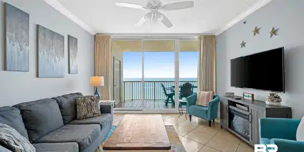 Image 3: Living area featuring tile flooring, crown molding, a ceiling fan, and sliding glass doors opening to an exterior balcony with water scenery