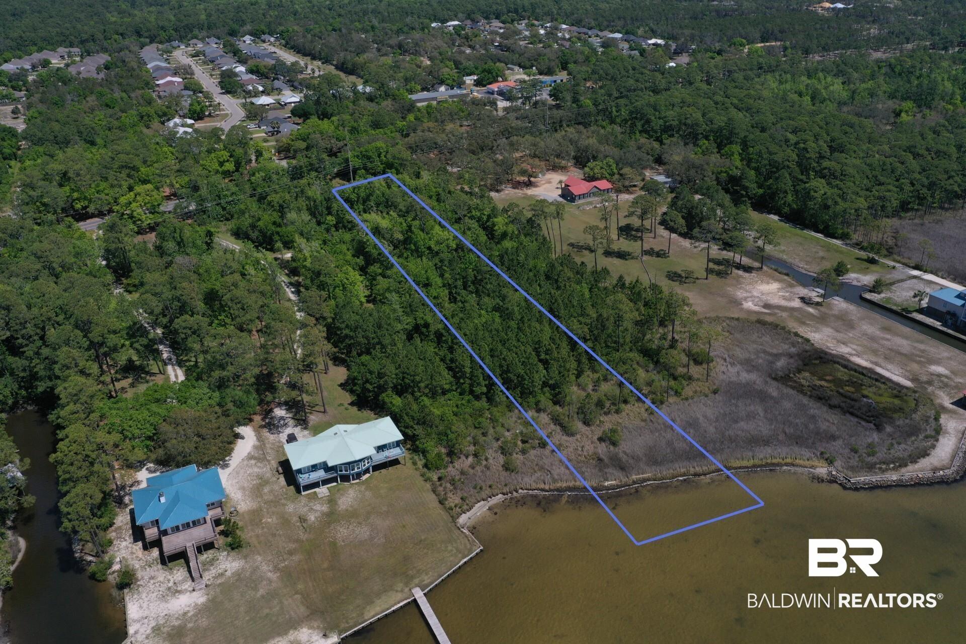 Image 2: Aerial view of property and surrounding area featuring property boundaries highlighted and a forest