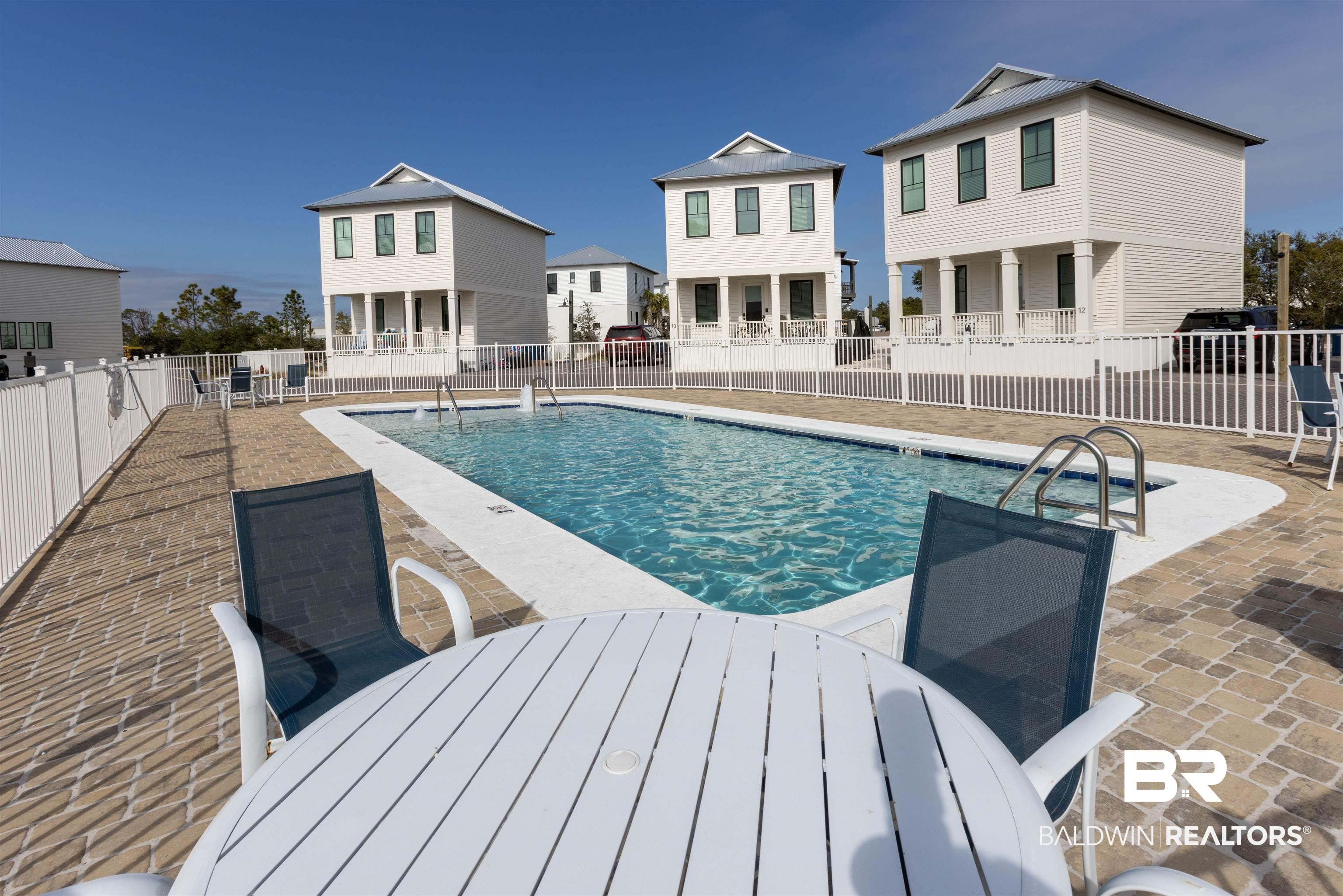 Image 2: Community pool featuring a patio and outdoor dining space