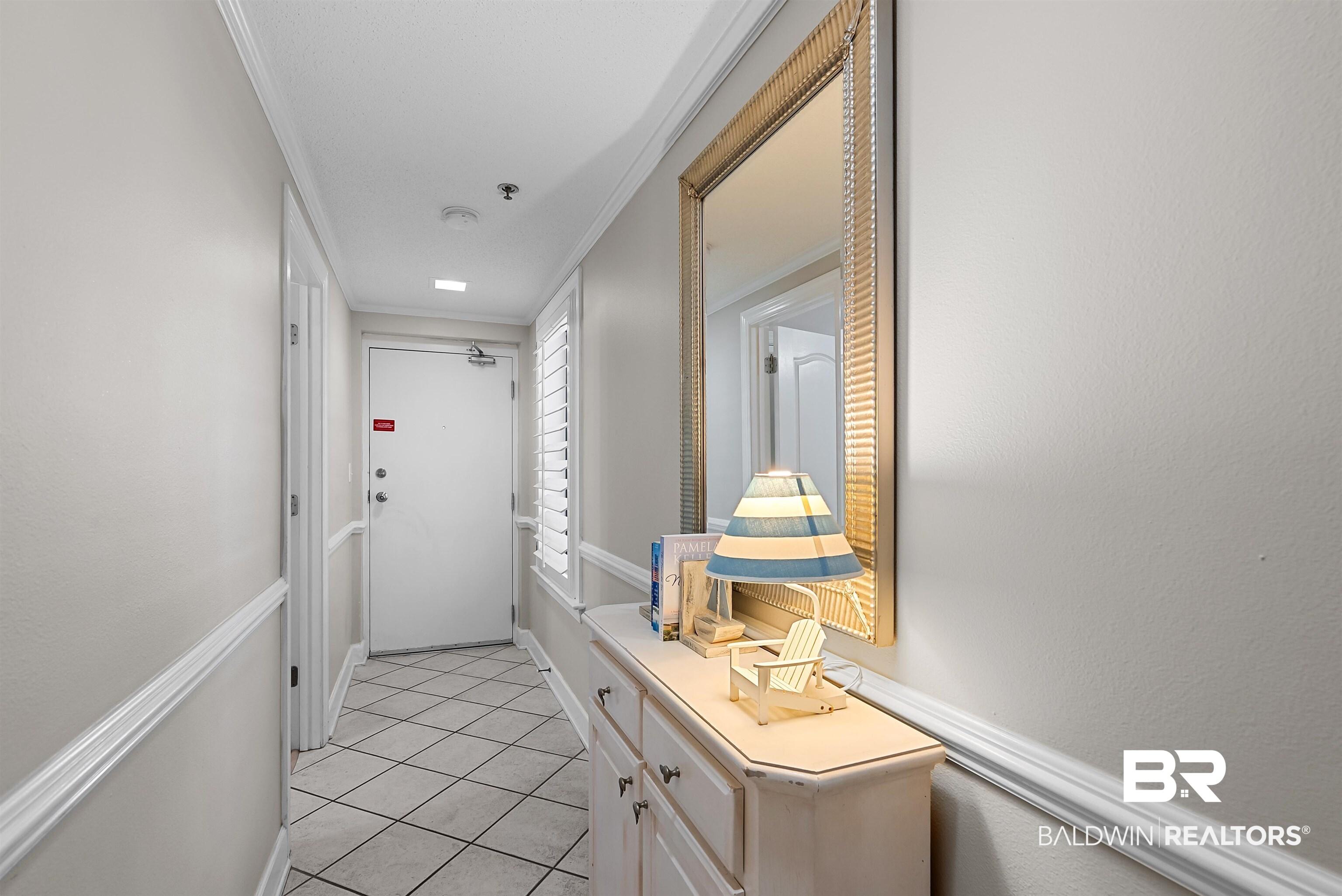 Image 4: Entry hallway featuring diagonal tile flooring, white baseboards, and chair rail molding
