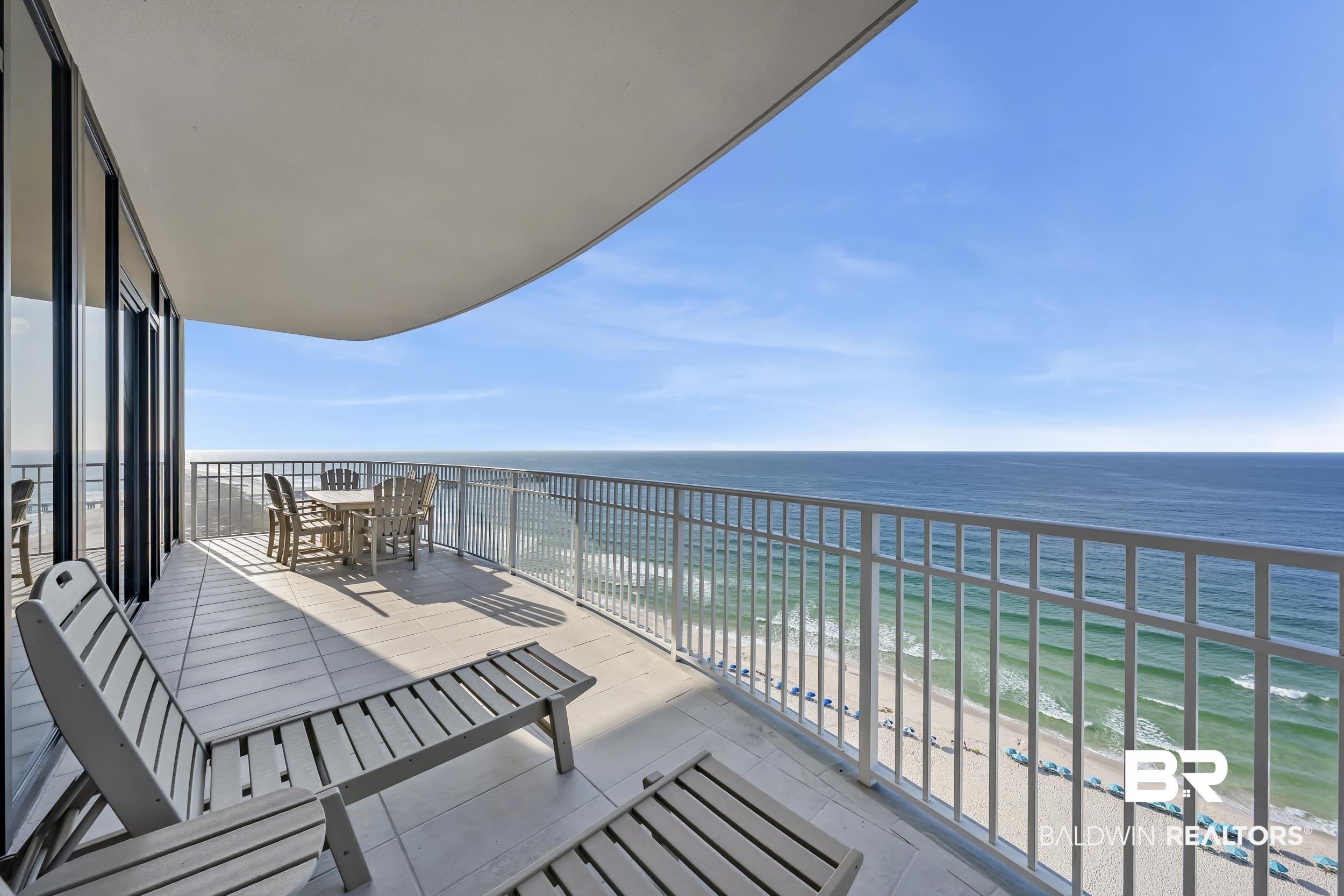 Image 3: Expansive private balcony featuring a tiled surface, curved overhead soffit, and a white metal railing