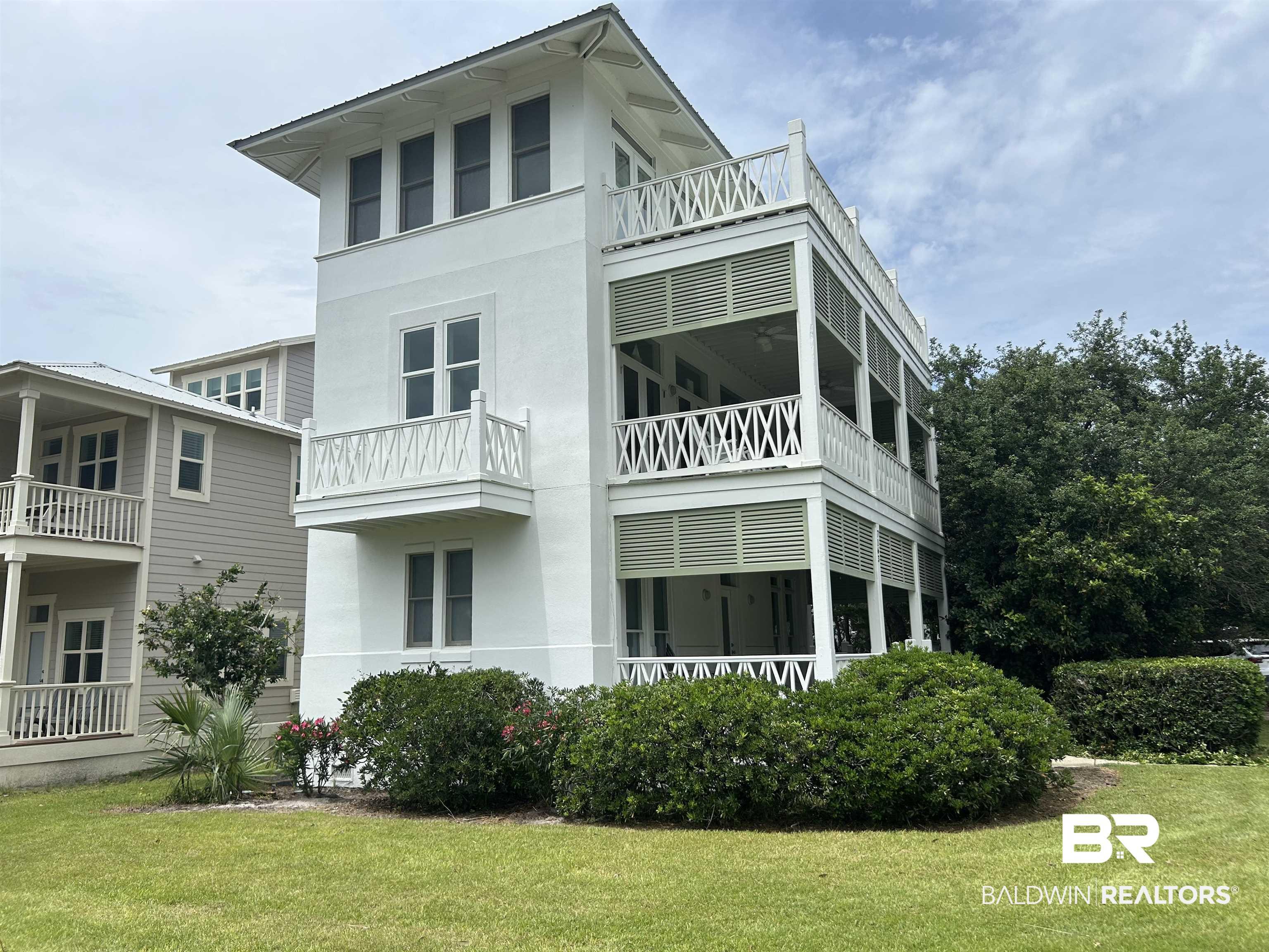 Image 1: Three-story white stucco residence featuring multiple screened porches, decorative balustrades, and a prominent third-story balcony