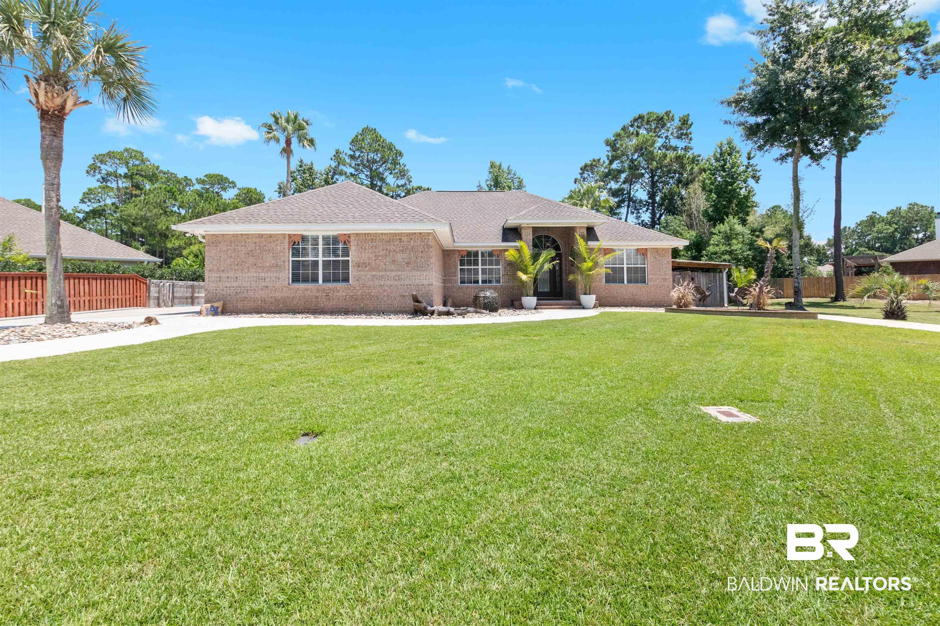 Image 2: Brick exterior residence featuring a gabled roofline and a large, flat lawn