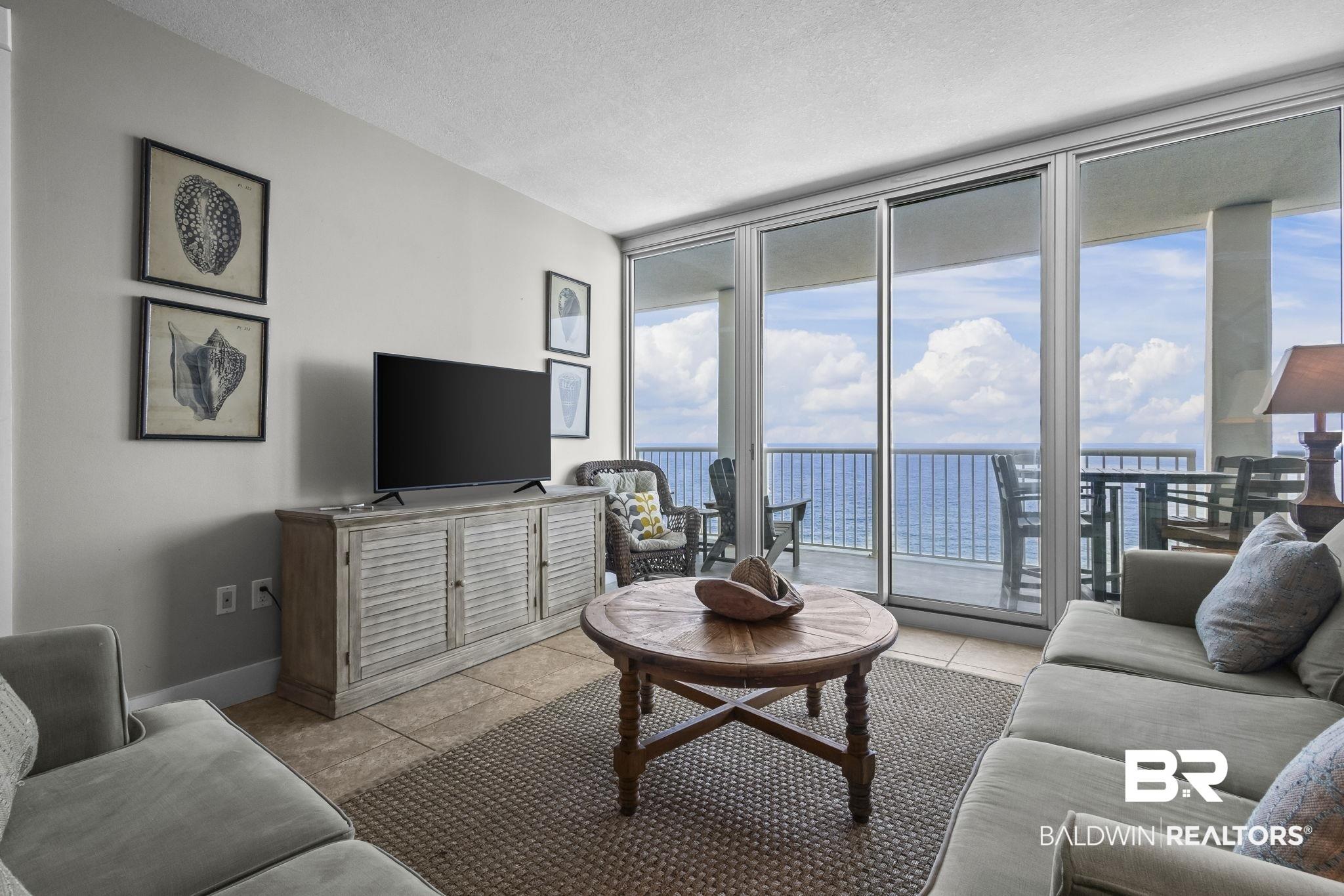 Image 3: Living area featuring floor to ceiling windows, a textured ceiling, and light tile patterned floors