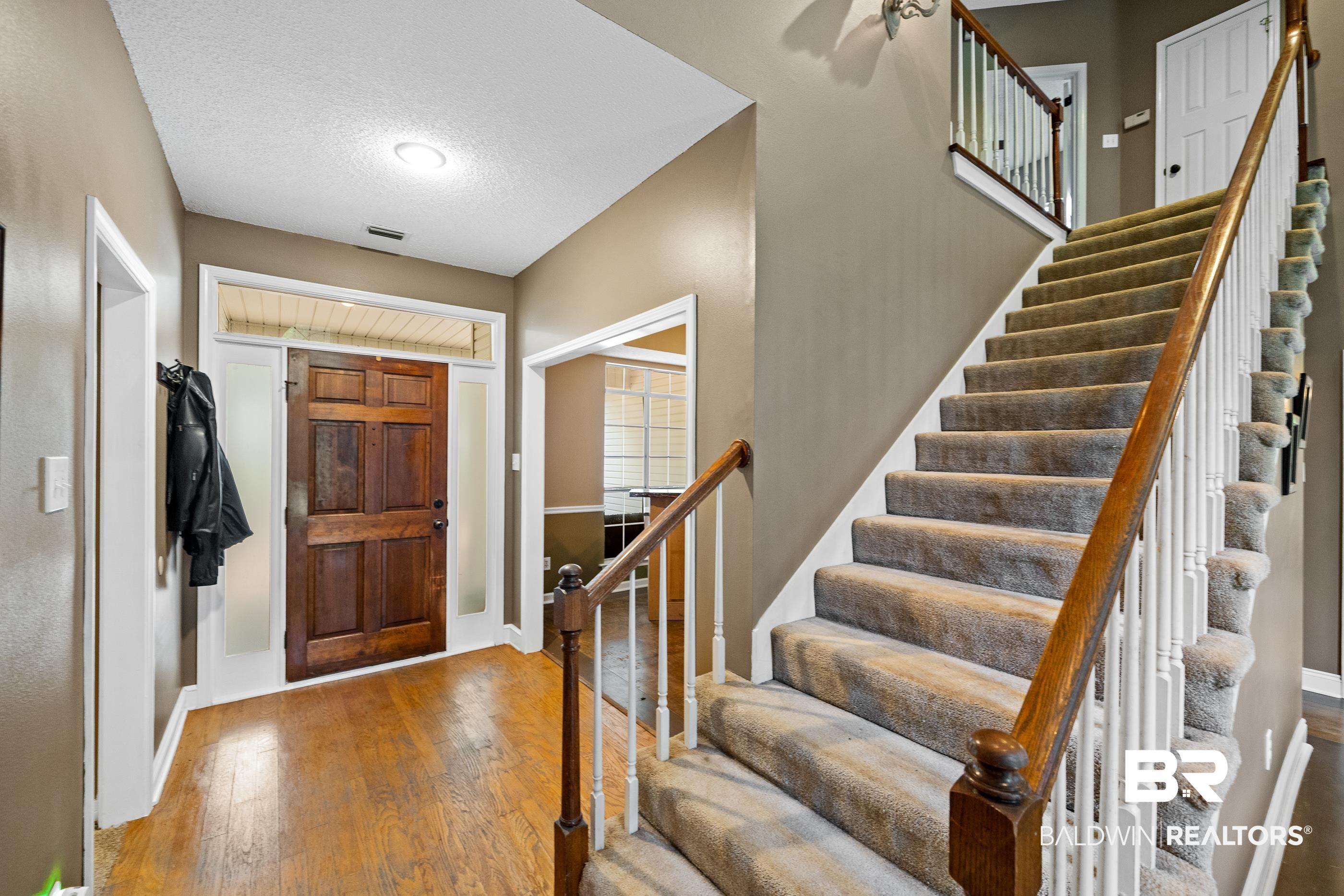 Image 3: Two-story foyer featuring a wood-panel entry door with sidelights and transom window