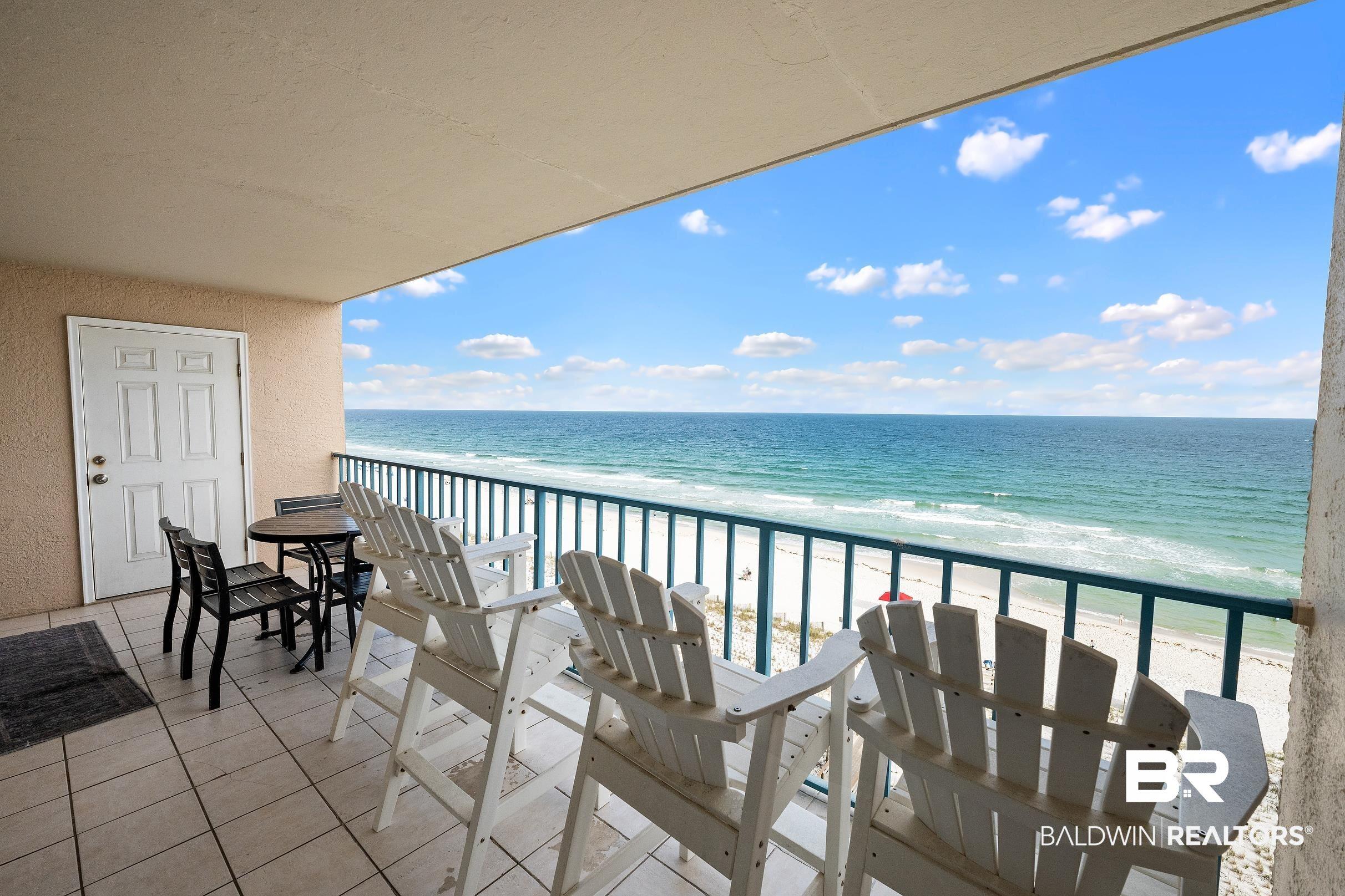 Image 4: Expansive balcony featuring a tile floor, white railing, and a direct oceanfront backdrop