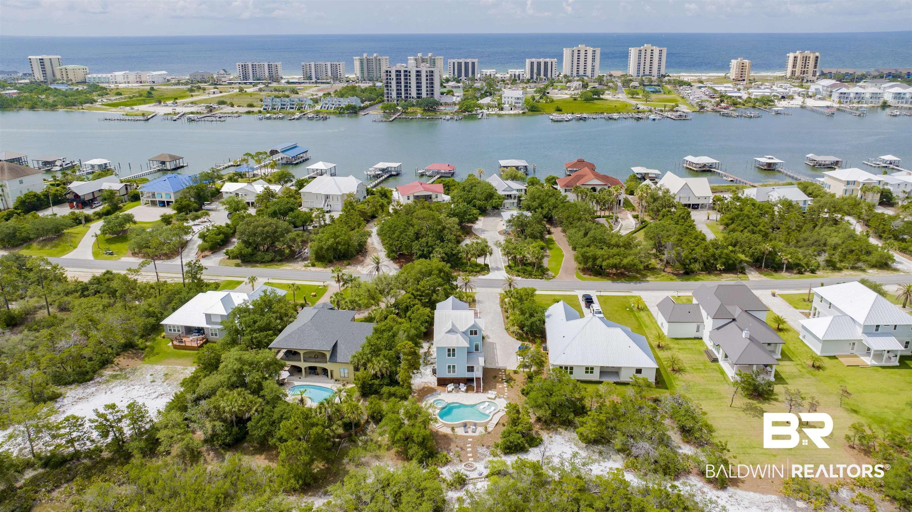 Image 4: Aerial perspective showcasing multiple properties, a prominent waterway, and a distant coastline with structures