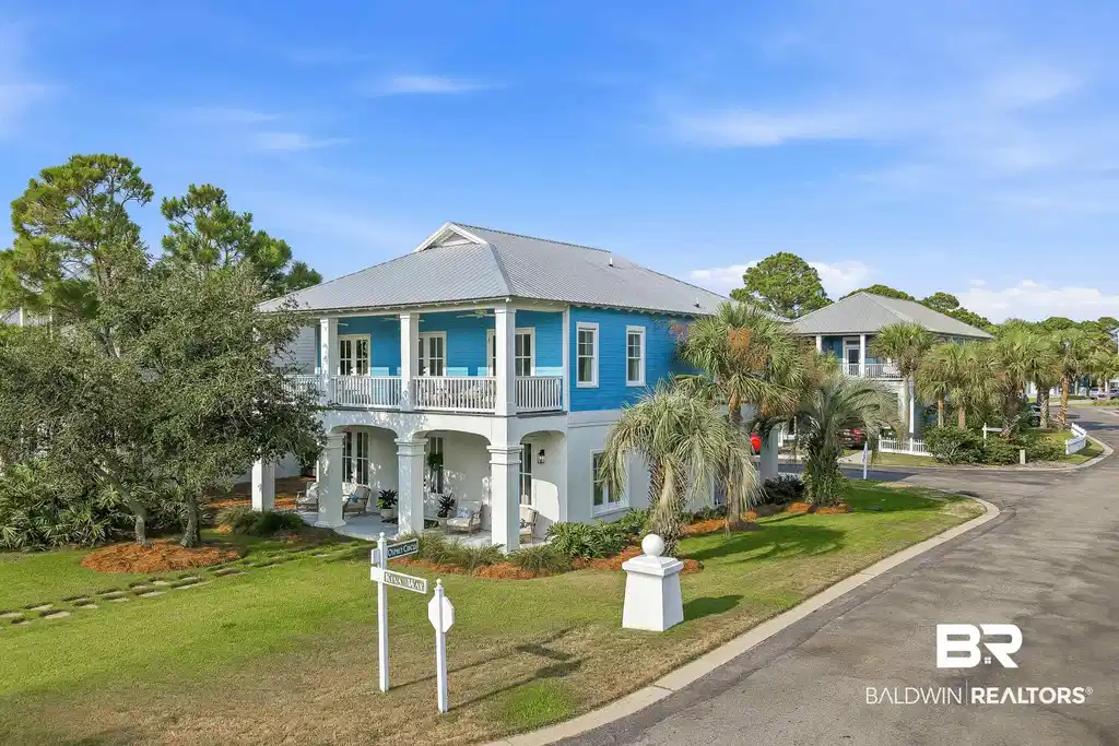 Image 1: Two-story residence featuring a blue and white facade with a metal roof