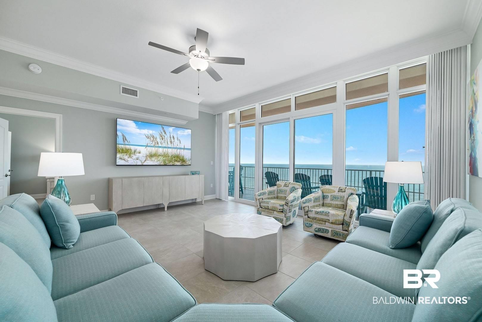 Image 2: Living area featuring ceiling fan, light tile patterned flooring, ornamental molding, and plenty of natural light