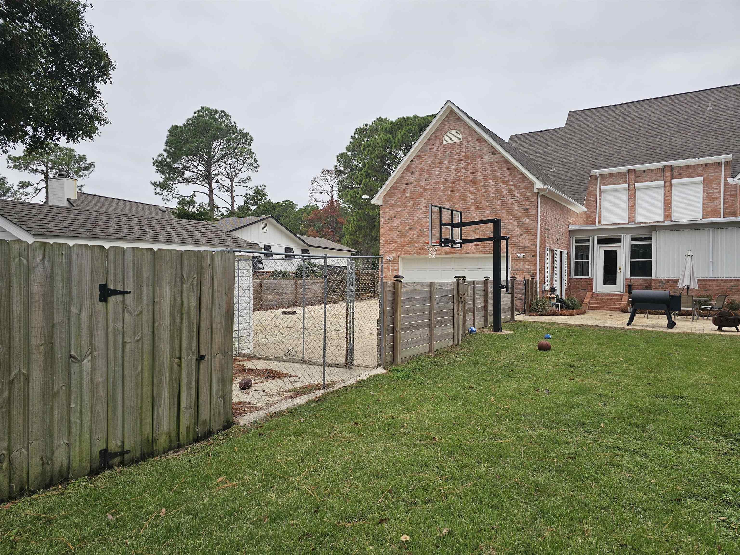 Image 3: View of yard featuring a patio, a garage, driveway, and an outbuilding