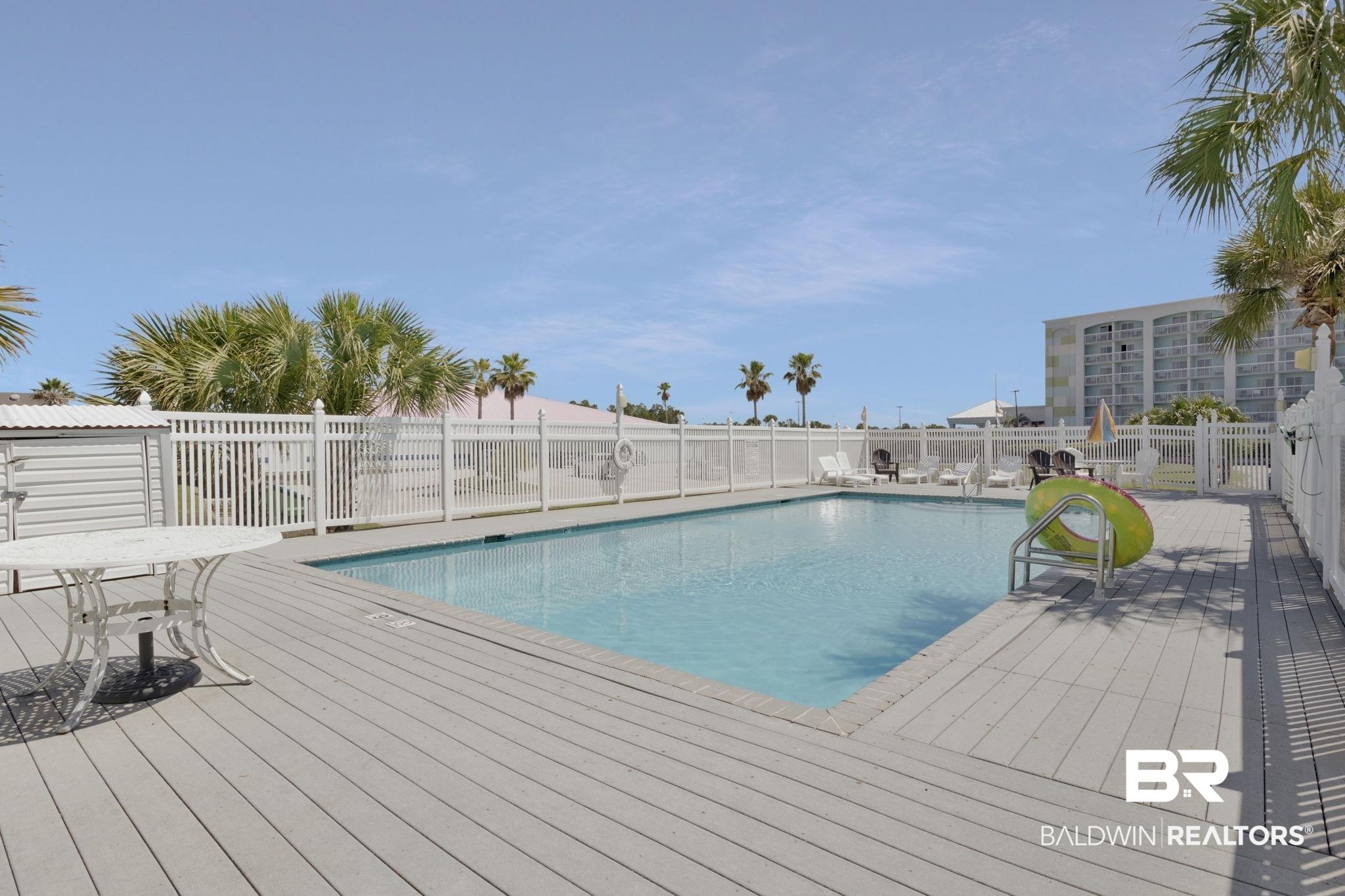 Image 3: Outdoor swimming pool surrounded by a composite wood-finish deck