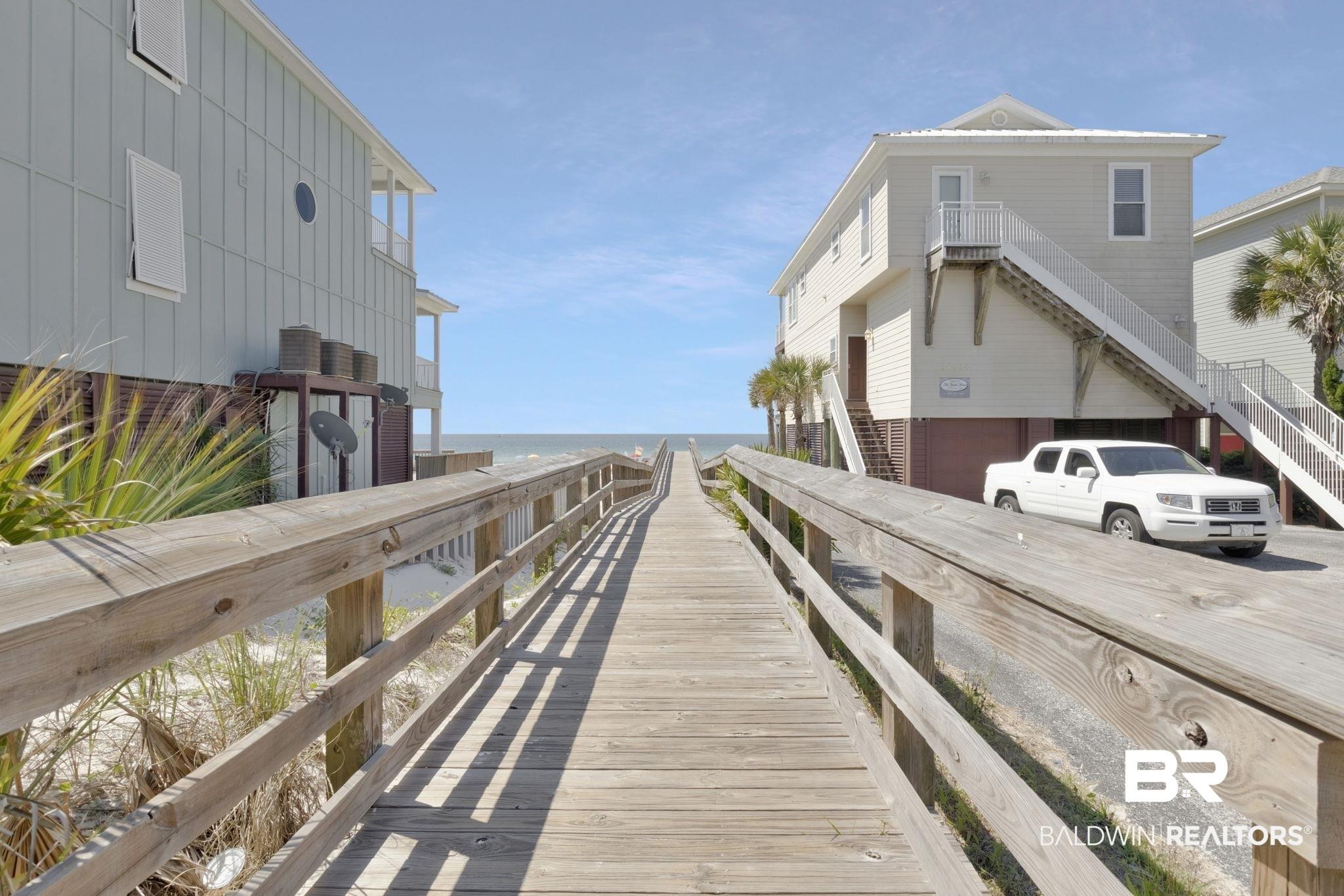 Image 4: Elevated coastal property featuring a light-colored exterior and multiple balconies