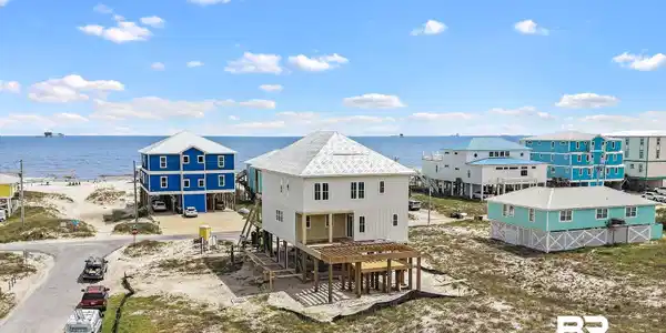 Image 2: Coastal-style residence featuring white siding and a multi-level design