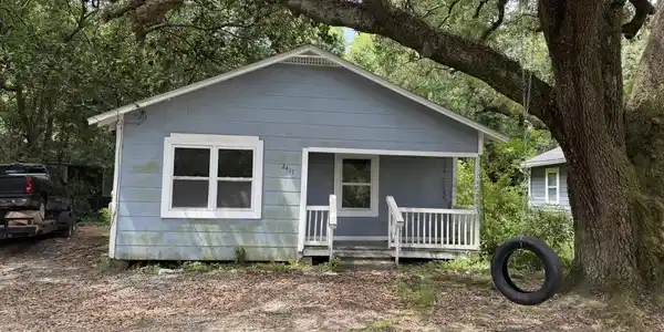 Image 2: Single-story residence featuring light blue siding with white trim