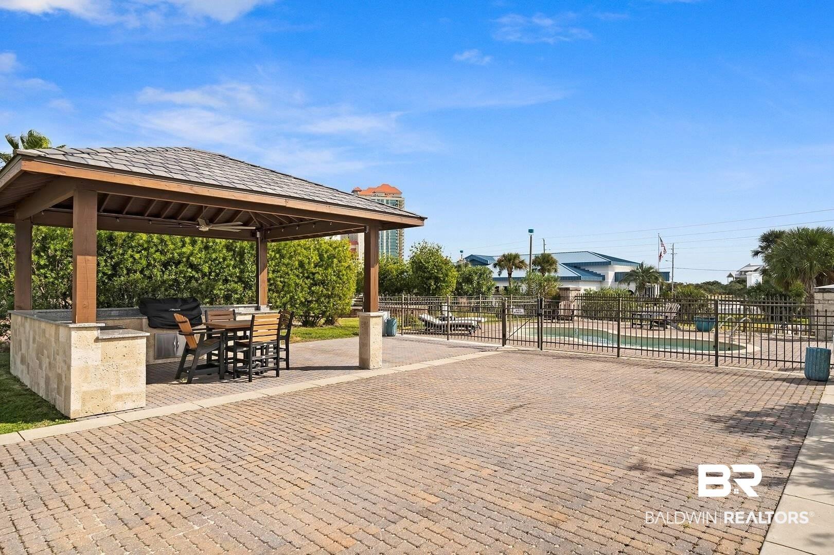 Image 3: View of home's community featuring a patio, a swimming pool, a bar, and a gazebo