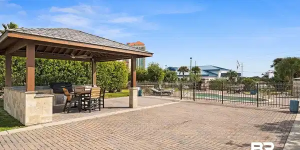 Image 3: View of home's community featuring a patio, a swimming pool, a bar, and a gazebo