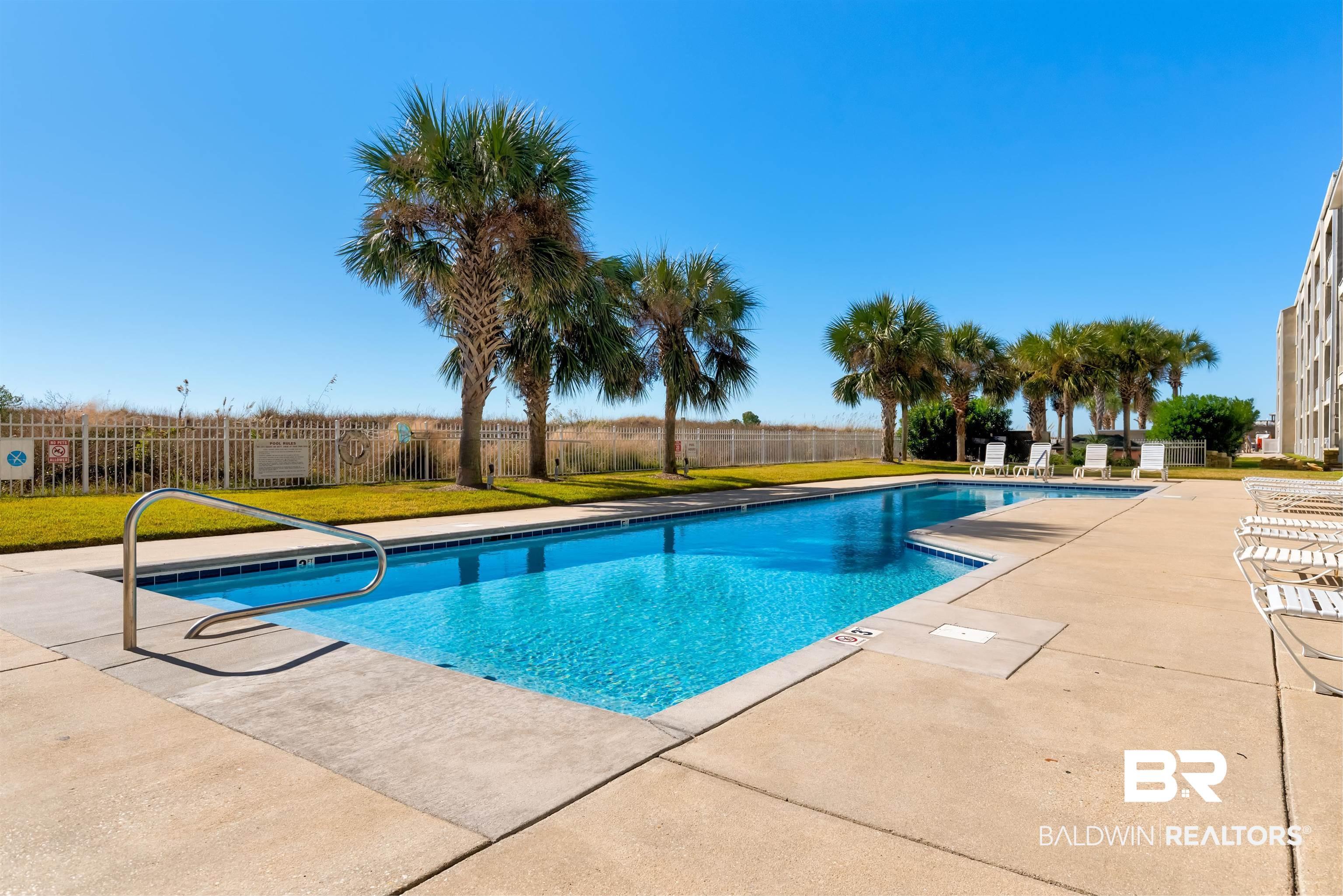 Image 3: Community pool featuring a patio