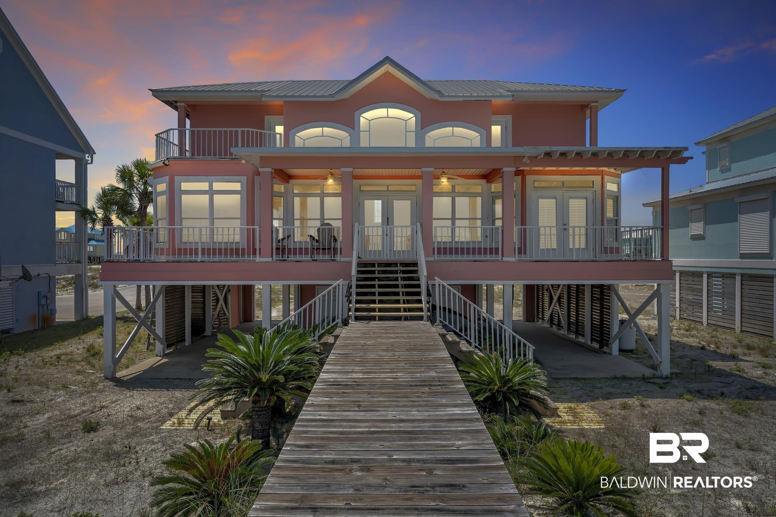 Image 2: Elevated coastal residence featuring a weathered wood pathway leading to a double-story porch
