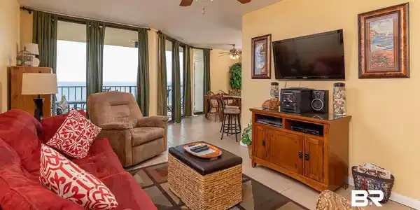 Image 2: Living area featuring tile flooring, a ceiling fan, and multiple floor-to-ceiling glass doors