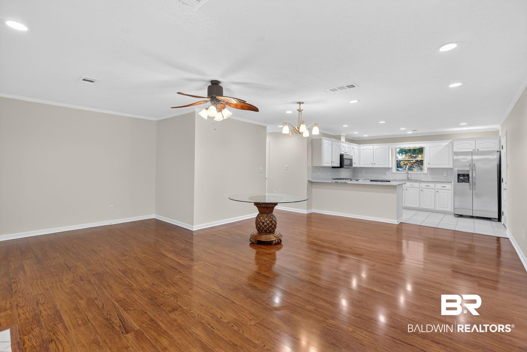 Image 4: Unfurnished living room featuring recessed lighting, a chandelier, light wood finished floors, crown molding, and ceiling fan