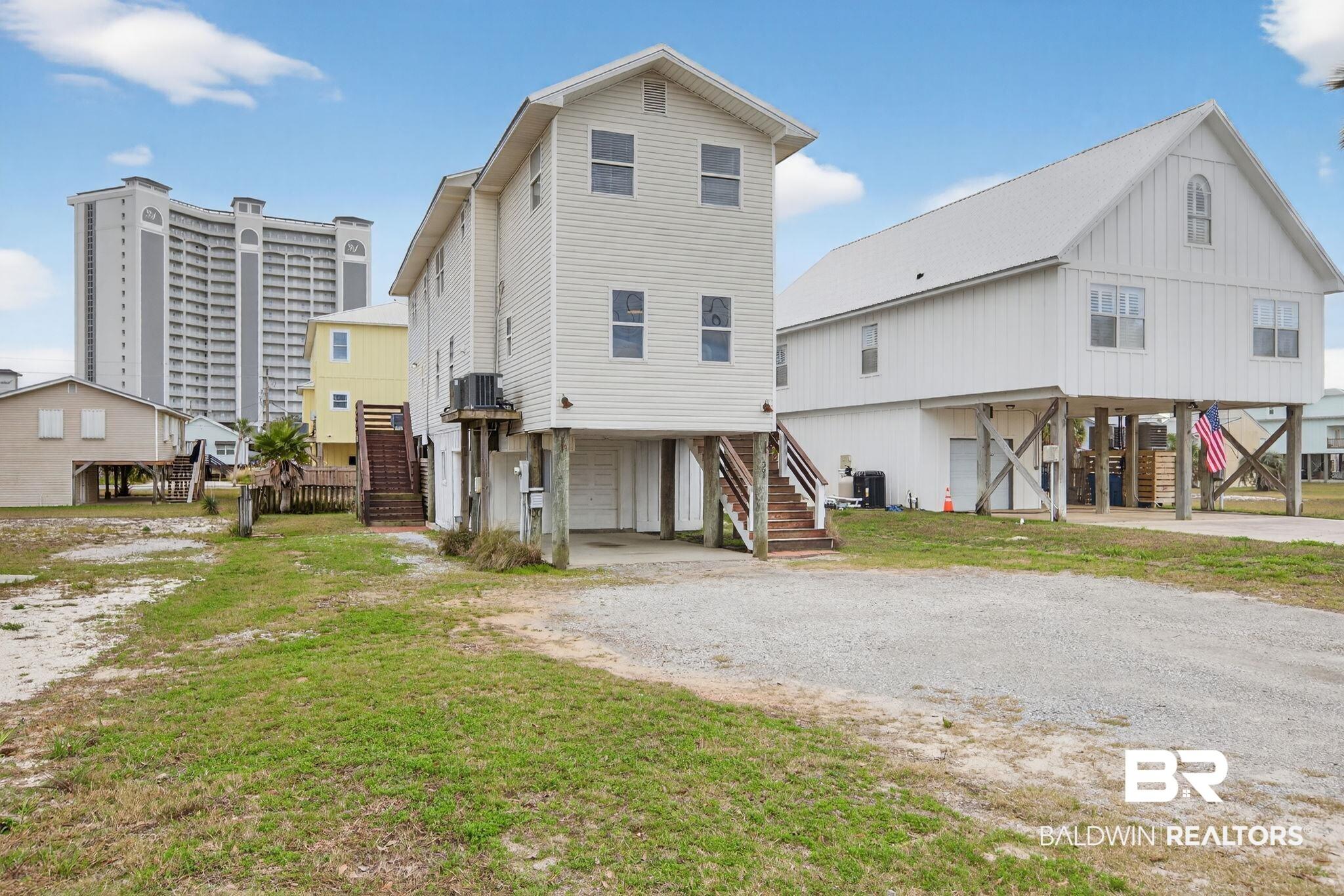 Image 3: Rear view of property featuring a carport and stairway