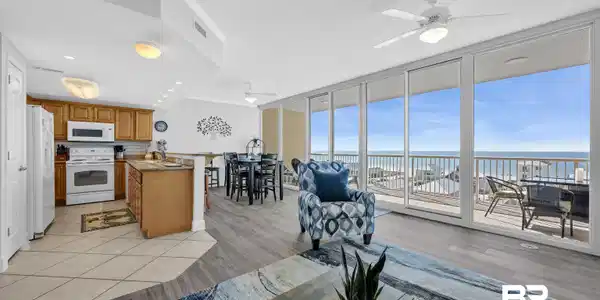 Image 3: Living area featuring expansive windows, ceiling fan, light wood-style flooring, a water view, and ornamental molding