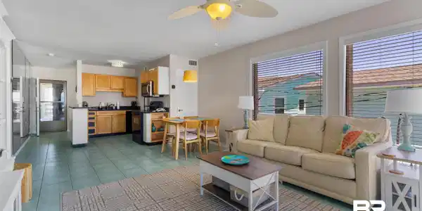 Image 2: Open-concept living space featuring light-colored walls, tile flooring, and a ceiling fan