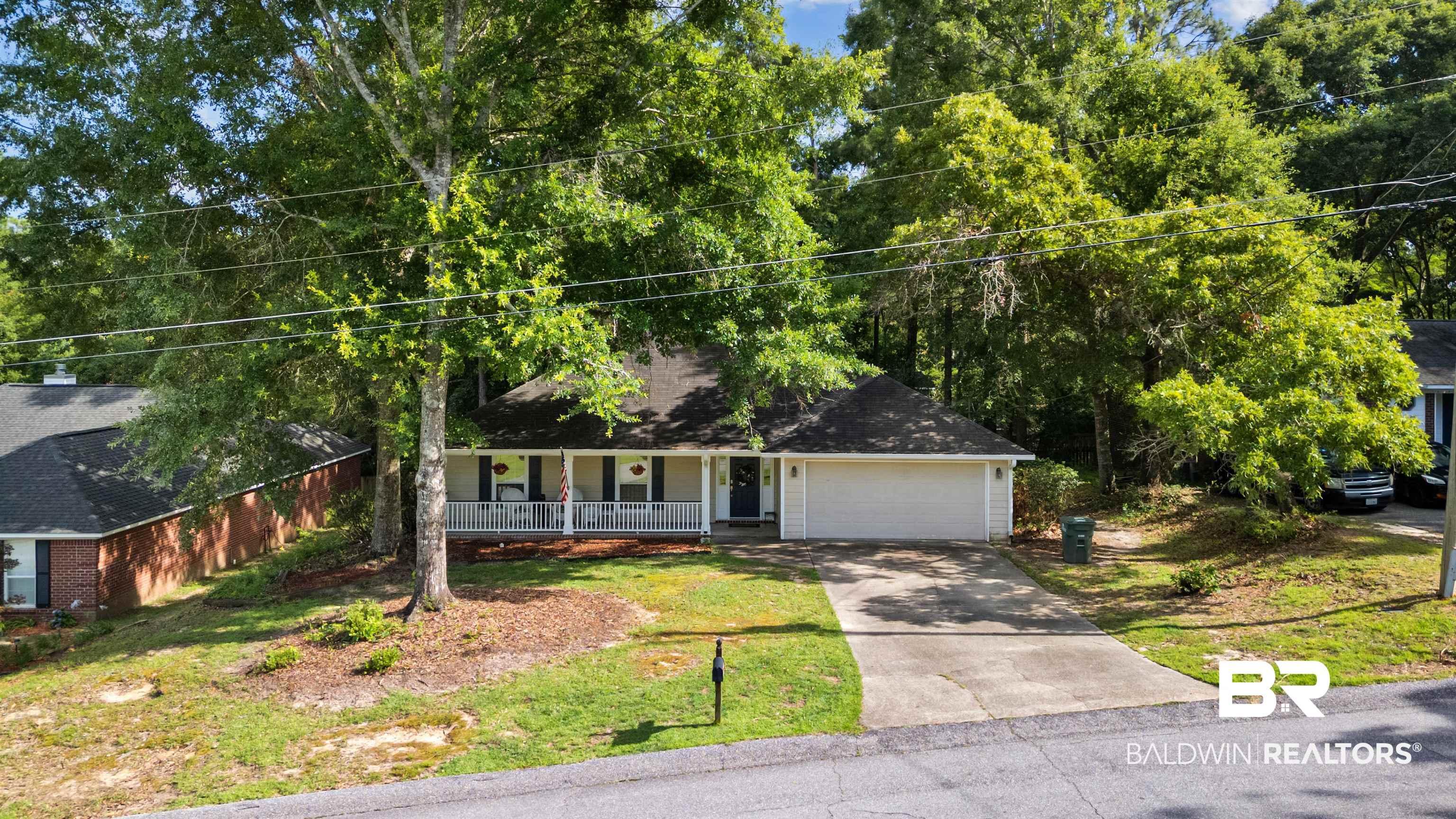 Image 2: Nestled beneath a canopy of established trees, this property offers a peaceful setting while remaining close to everything Daphne has to offer.