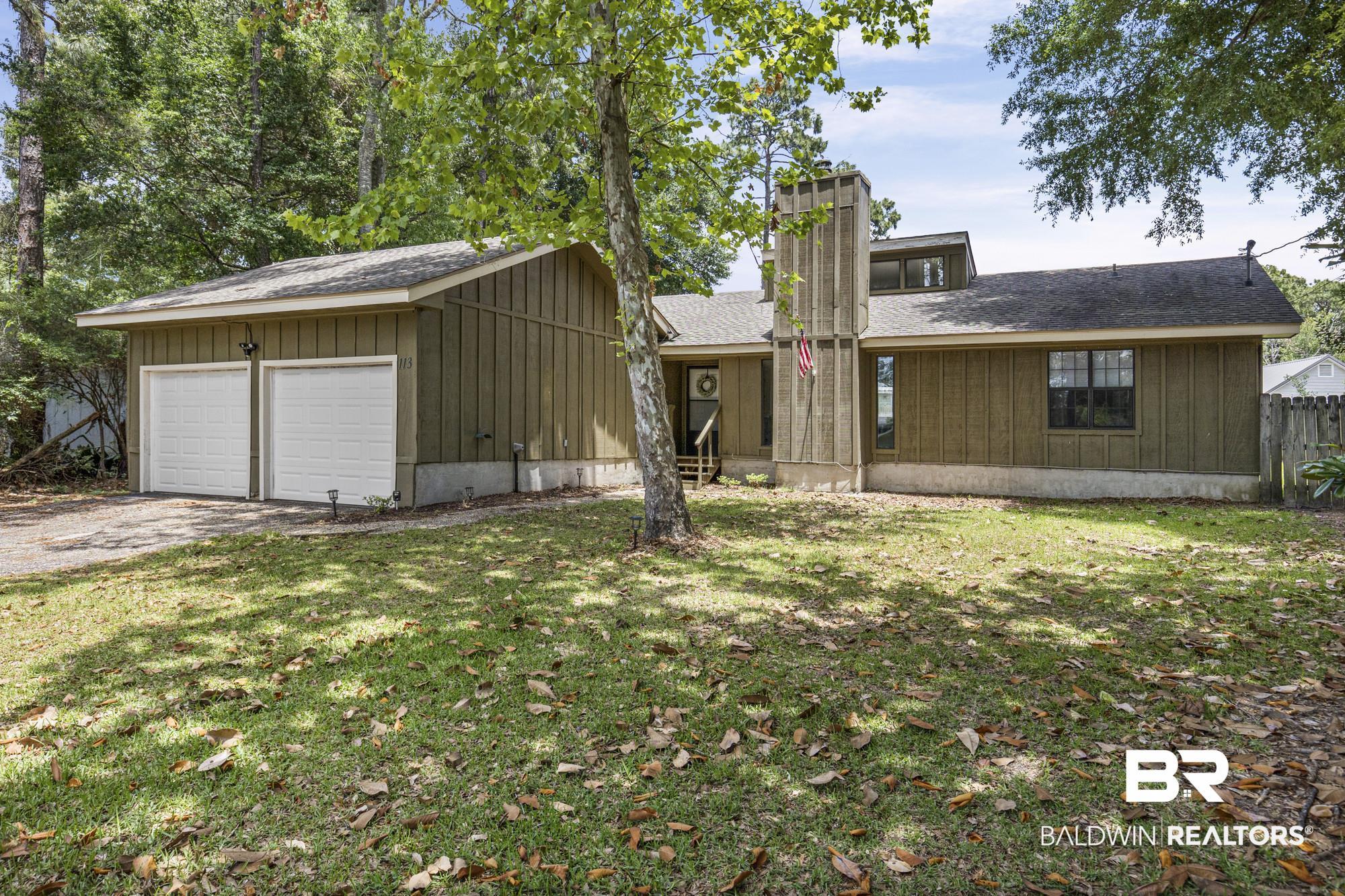 Image 4: Exterior featuring board and batten siding, a prominent chimney structure, a two-car garage with white doors, a front entry with steps, and a shingle roof