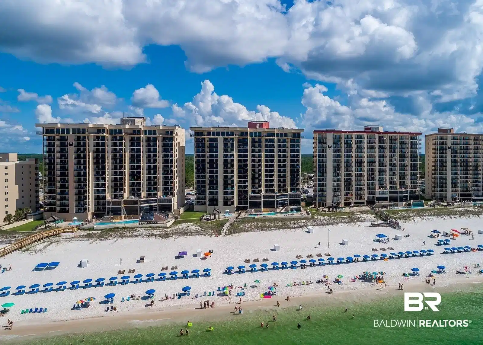 Image 1: Beachfront condominium buildings featuring private balconies, ground-level swimming pools, direct beach access, and a wide sandy beach