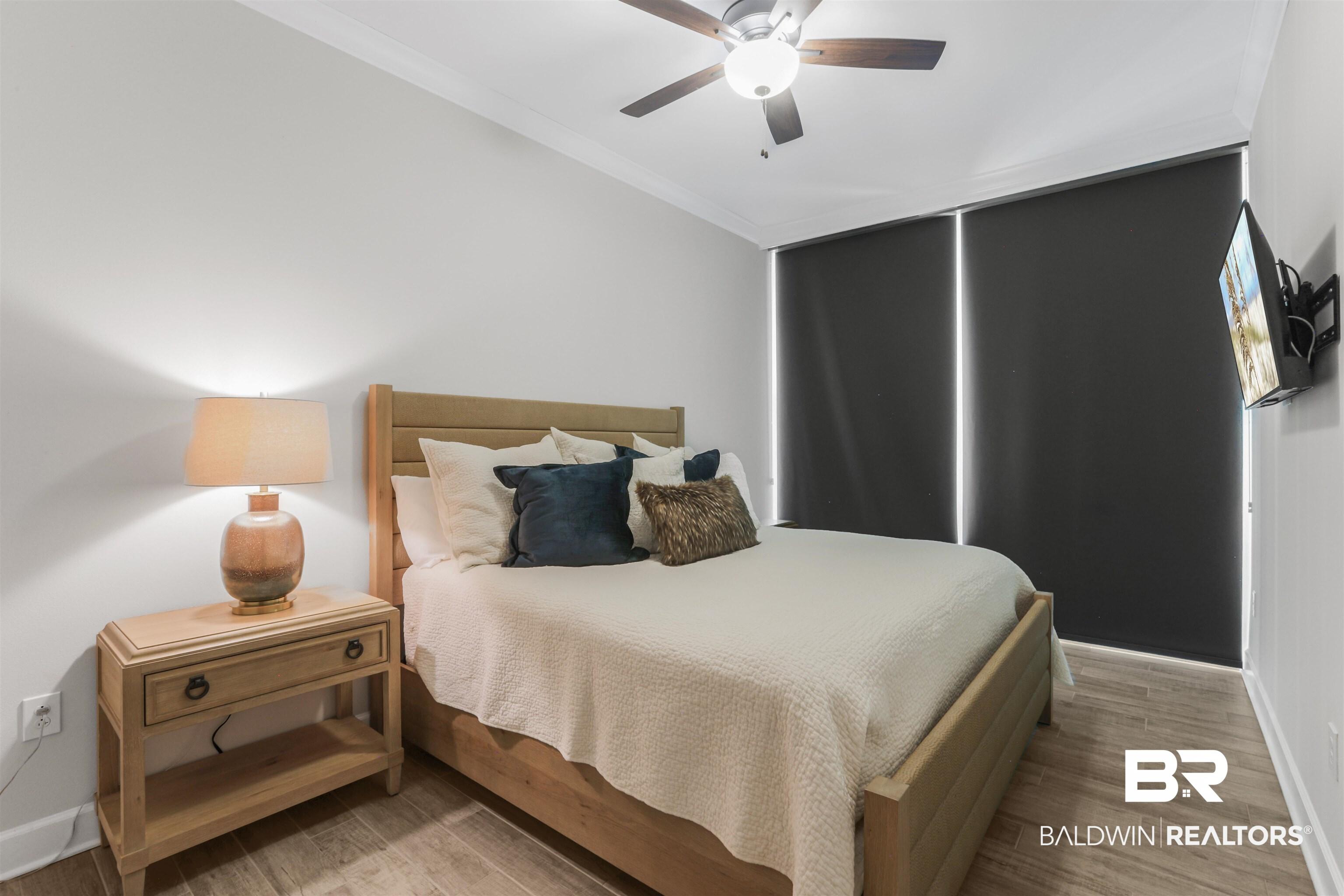 Image 2: Bedroom featuring light wood finished floors, ornamental molding, and a ceiling fan