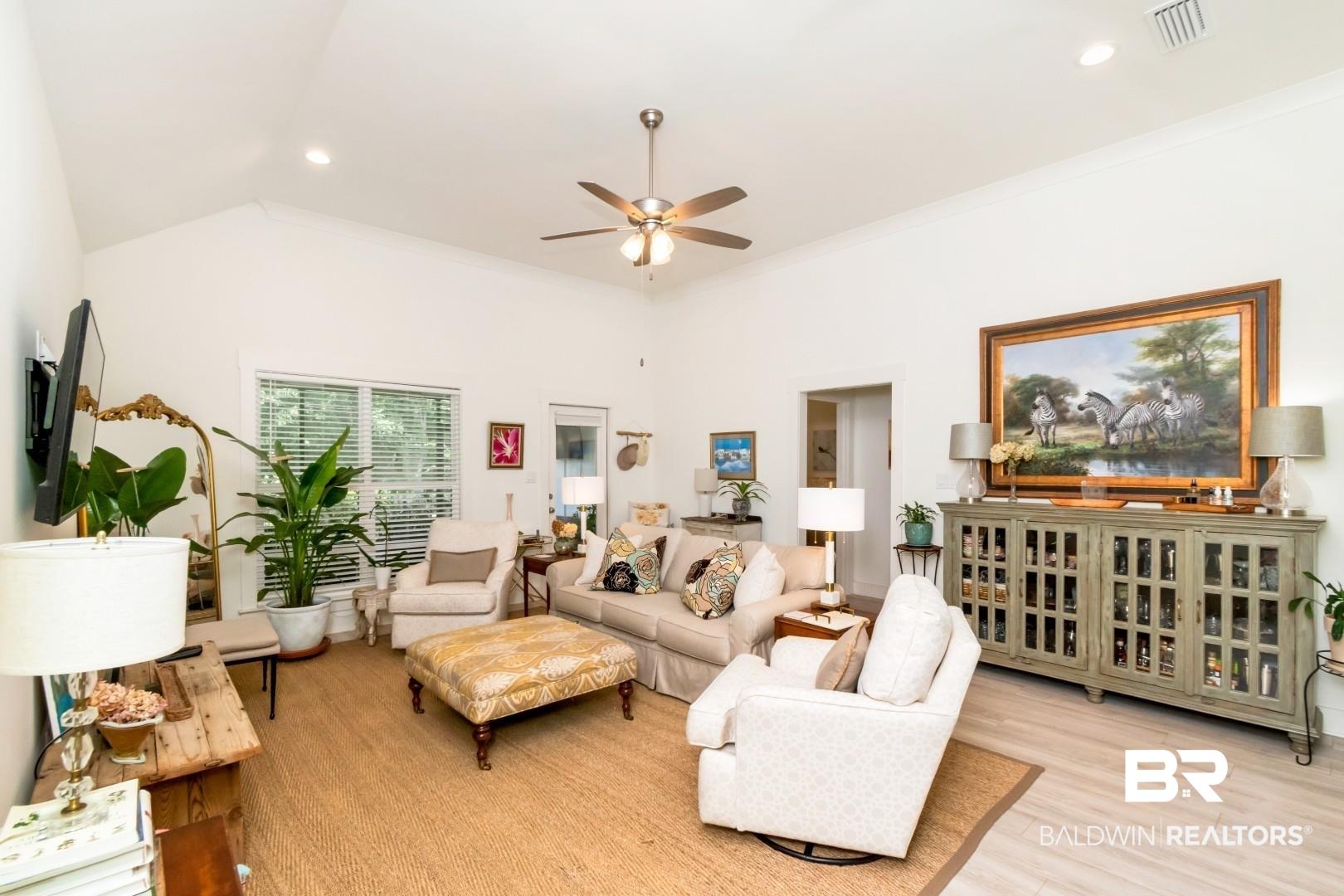 Image 4: Spacious living area featuring vaulted ceilings, light wood-finish flooring, and recessed lighting