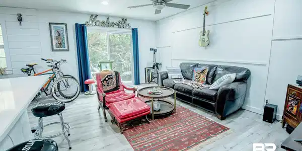 Image 2: Open-concept living space featuring wood-finish flooring, white shiplap paneling, and board and batten detailing
