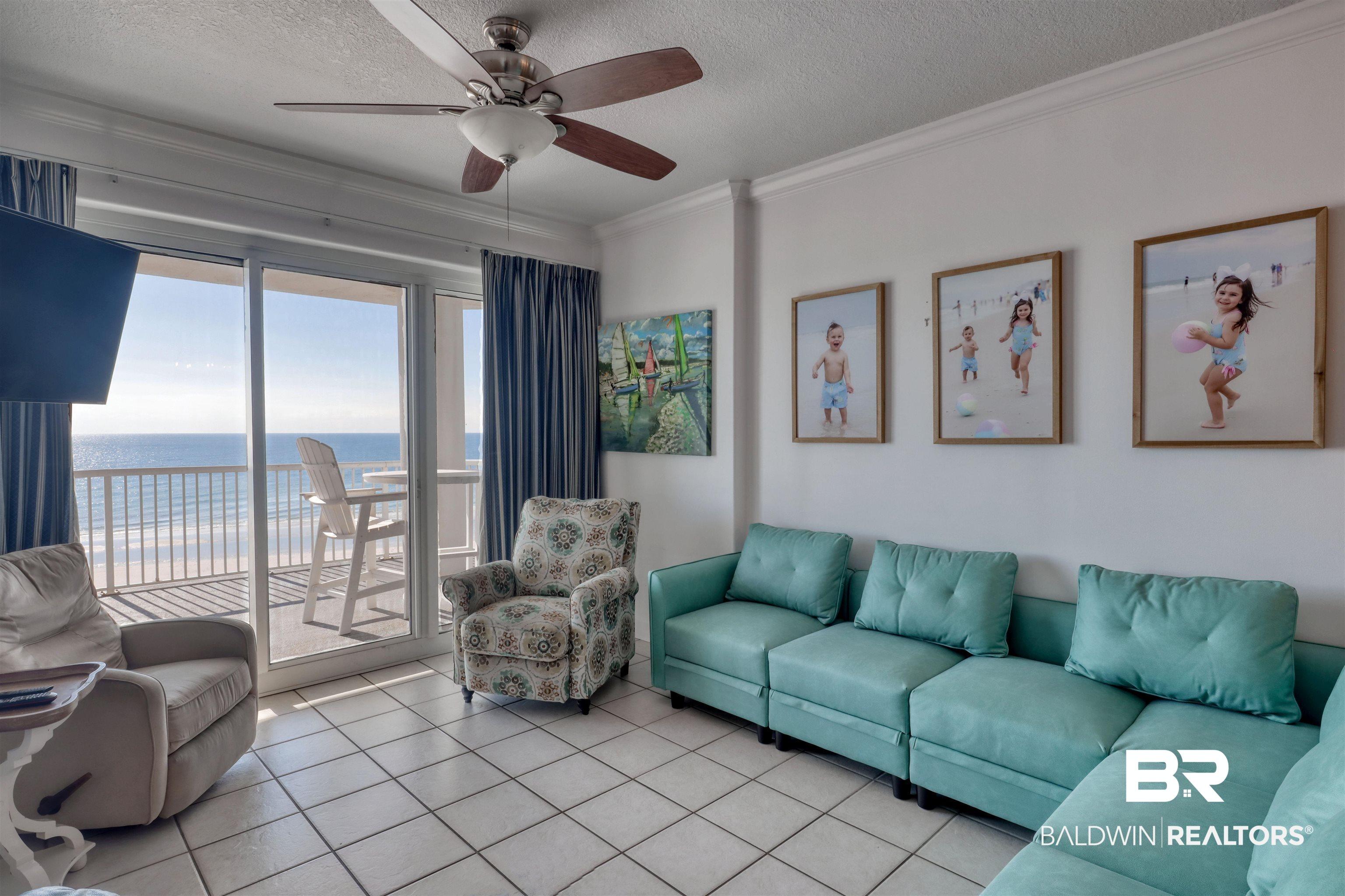 Image 2: Living room featuring a water view, crown molding, a textured ceiling, ceiling fan, and tile patterned flooring