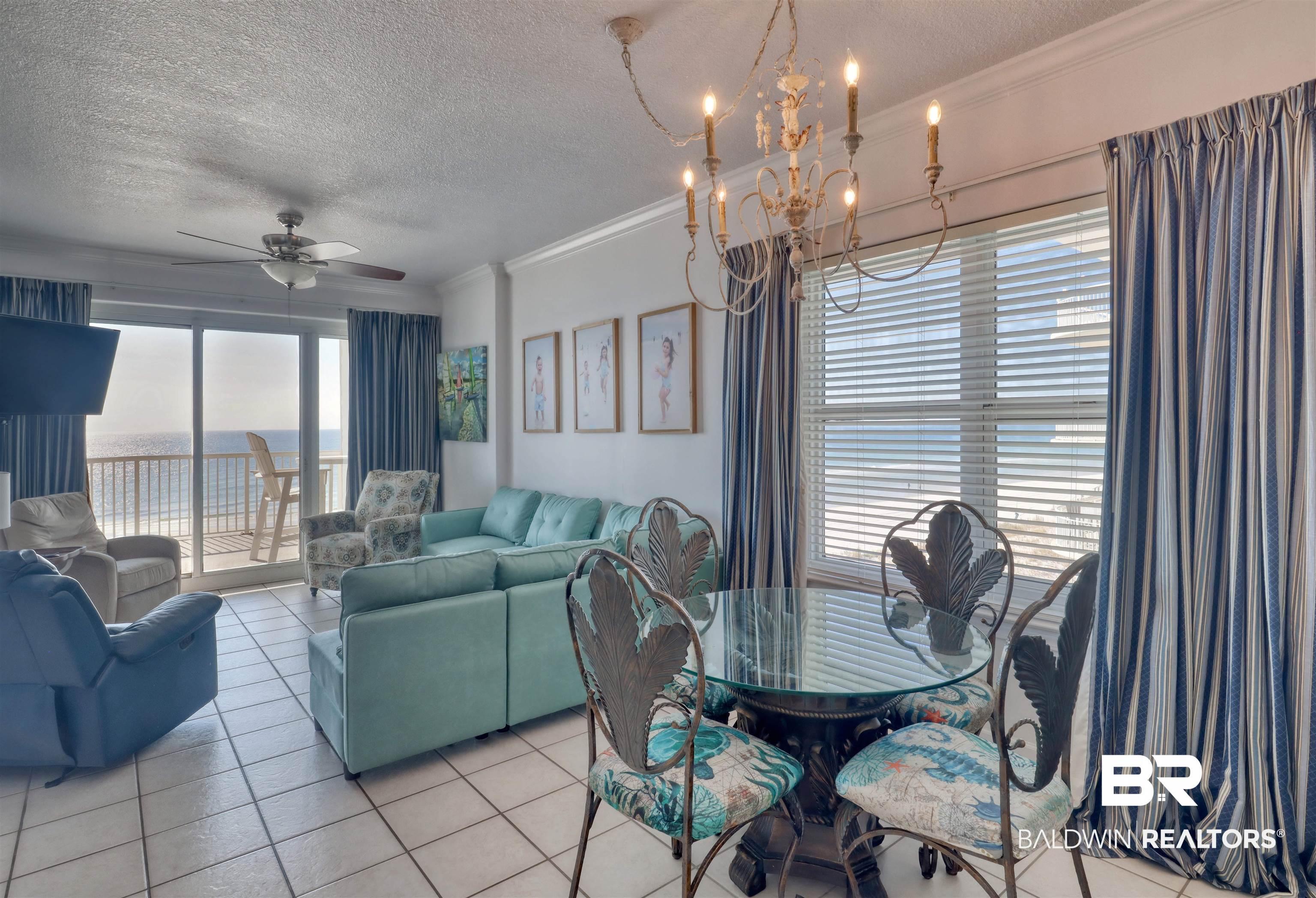 Image 4: Dining room featuring a textured ceiling, a ceiling fan, light tile patterned floors, crown molding, and a chandelier