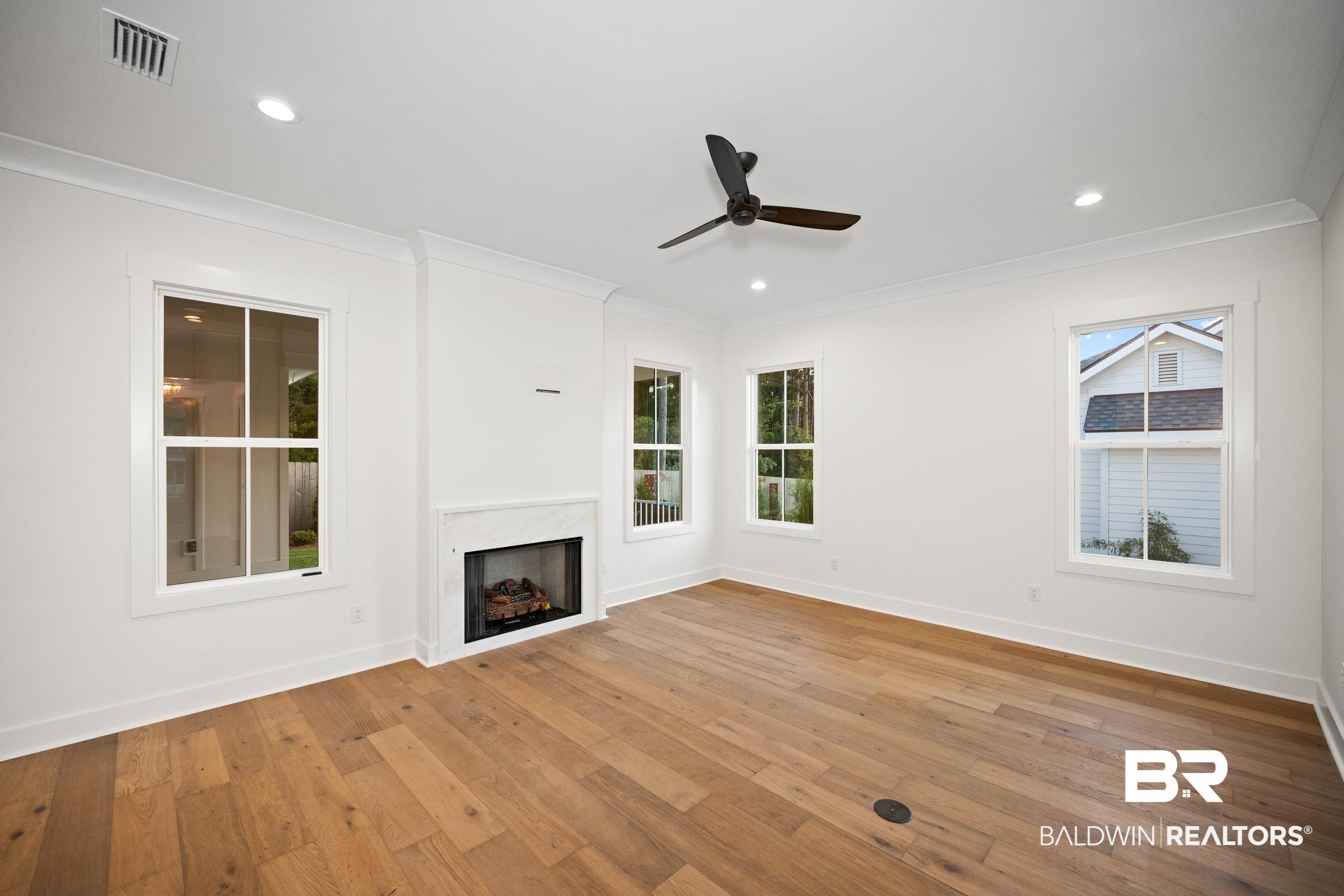 Image 3: Spacious room featuring wide plank wood-finish flooring
