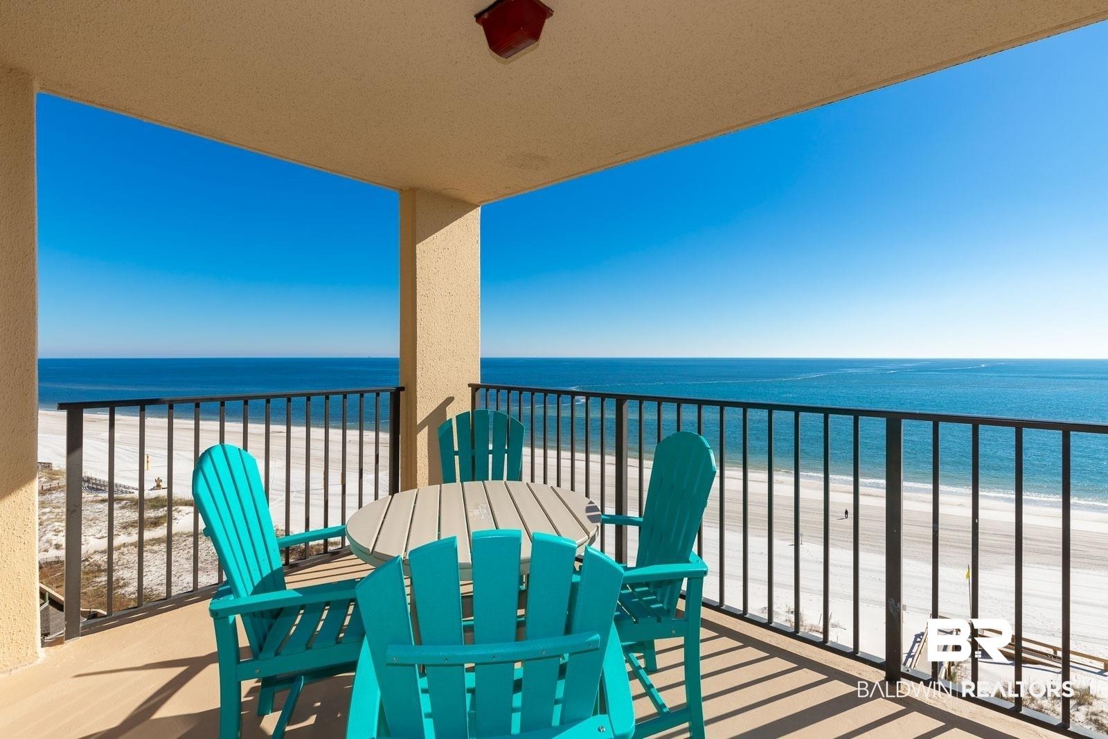 Image 4: Balcony featuring view of water and beach and outdoor dining space