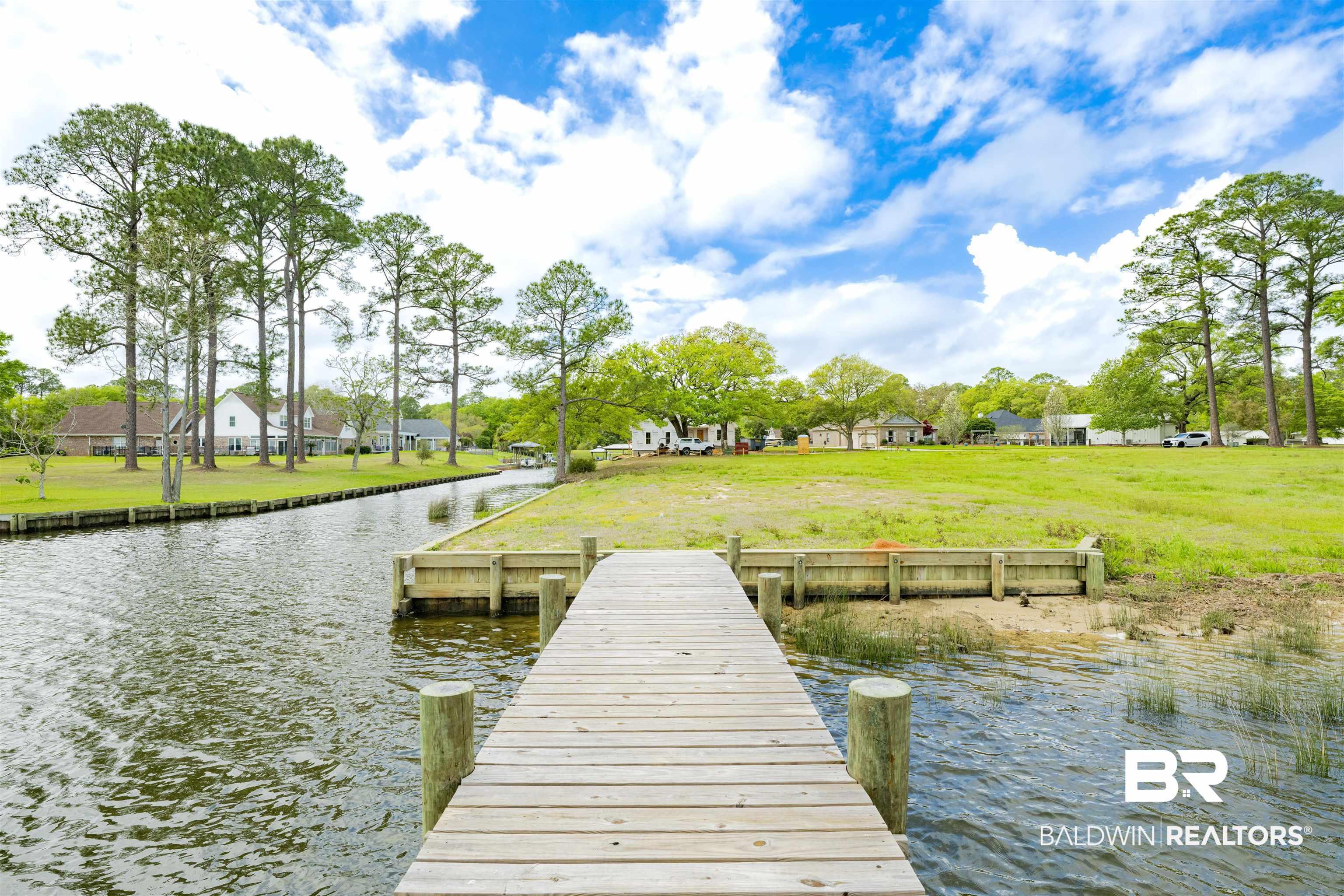 Image 4: Dock with a water view, a lawn, and a residential view