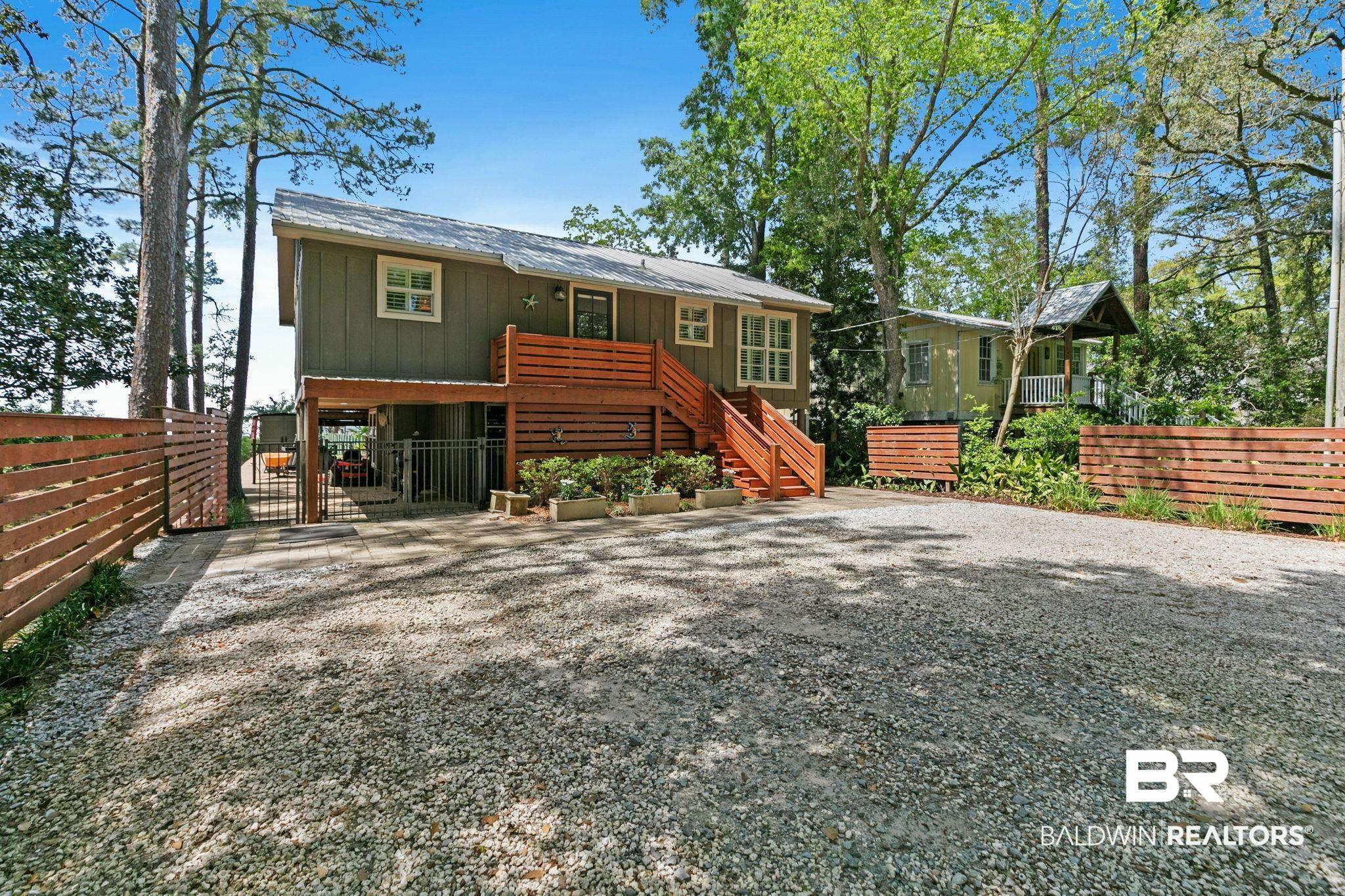 Image 4: View of property featuring board and batten siding and a gate
