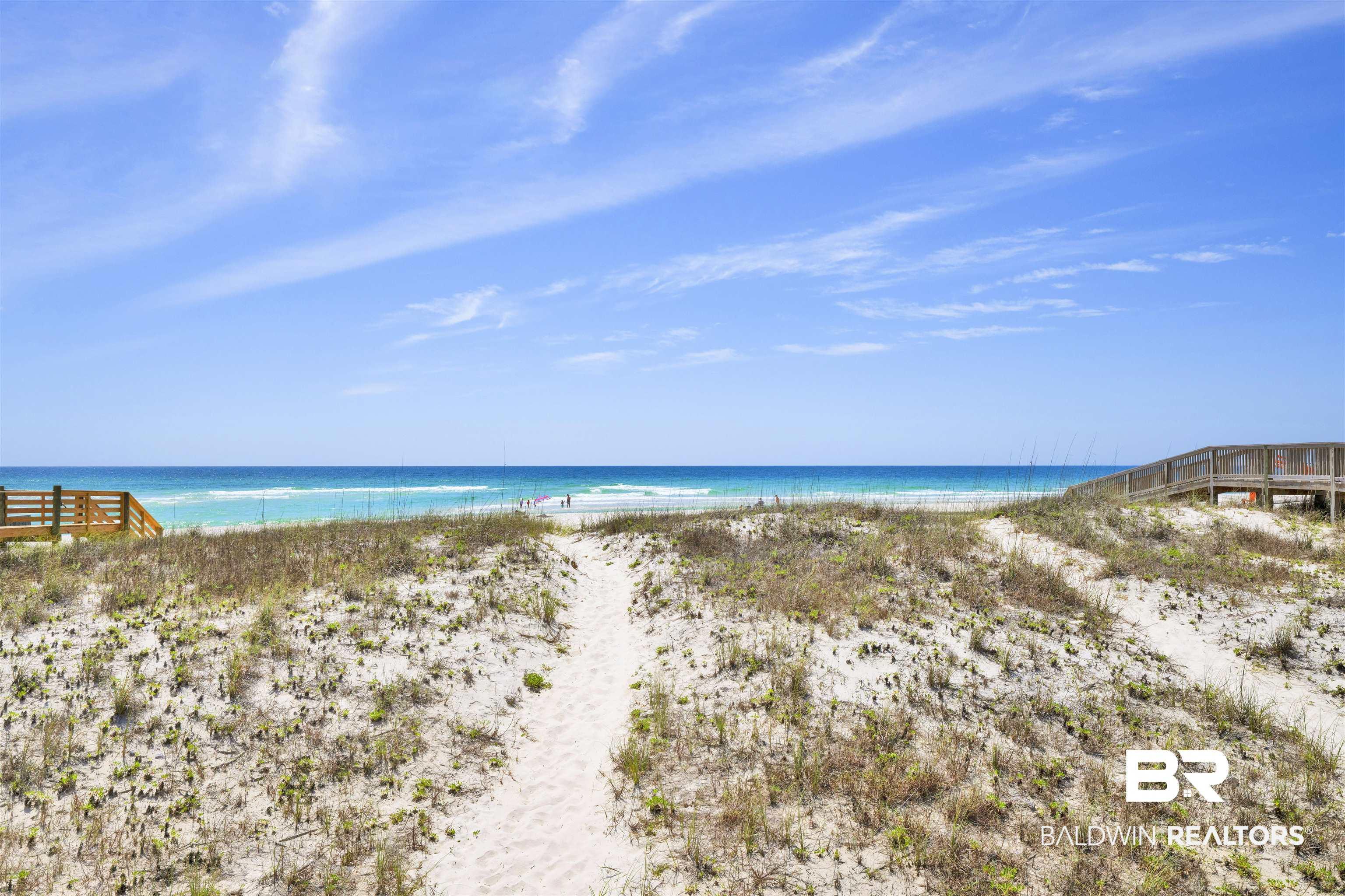 Image 4: Expansive sandy beach with a clear blue ocean backdrop