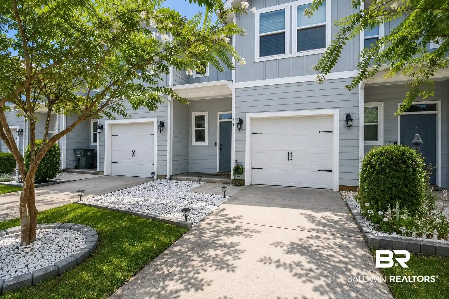 Image 1: Contemporary townhouse exterior featuring light blue siding with white trim