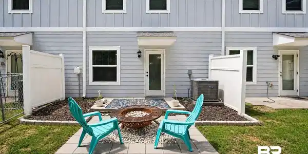 Image 3: Paved patio space featuring a fire pit with stone fill