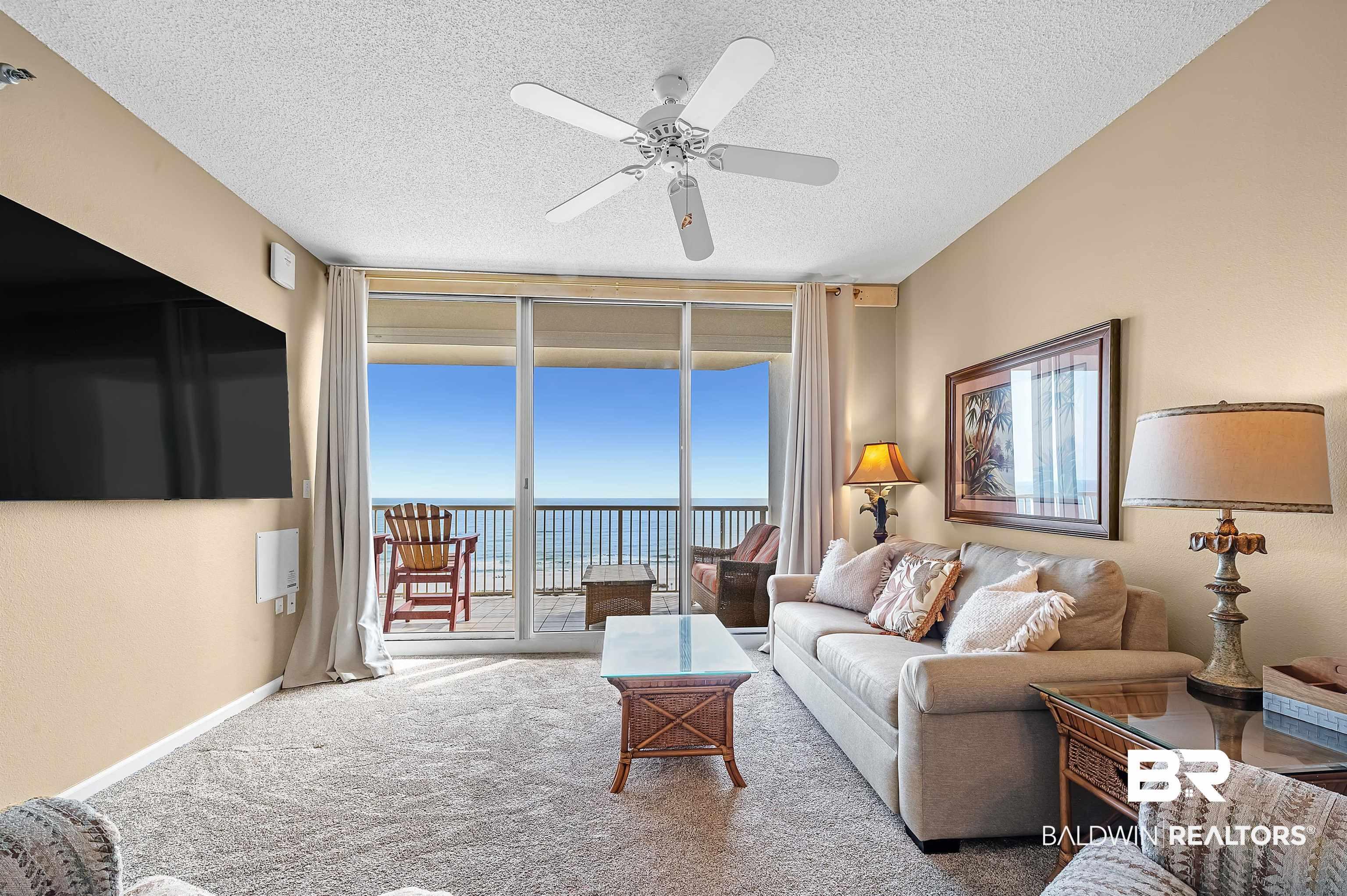 Image 3: Living room featuring baseboards, carpet, ceiling fan, floor to ceiling windows, and a textured ceiling