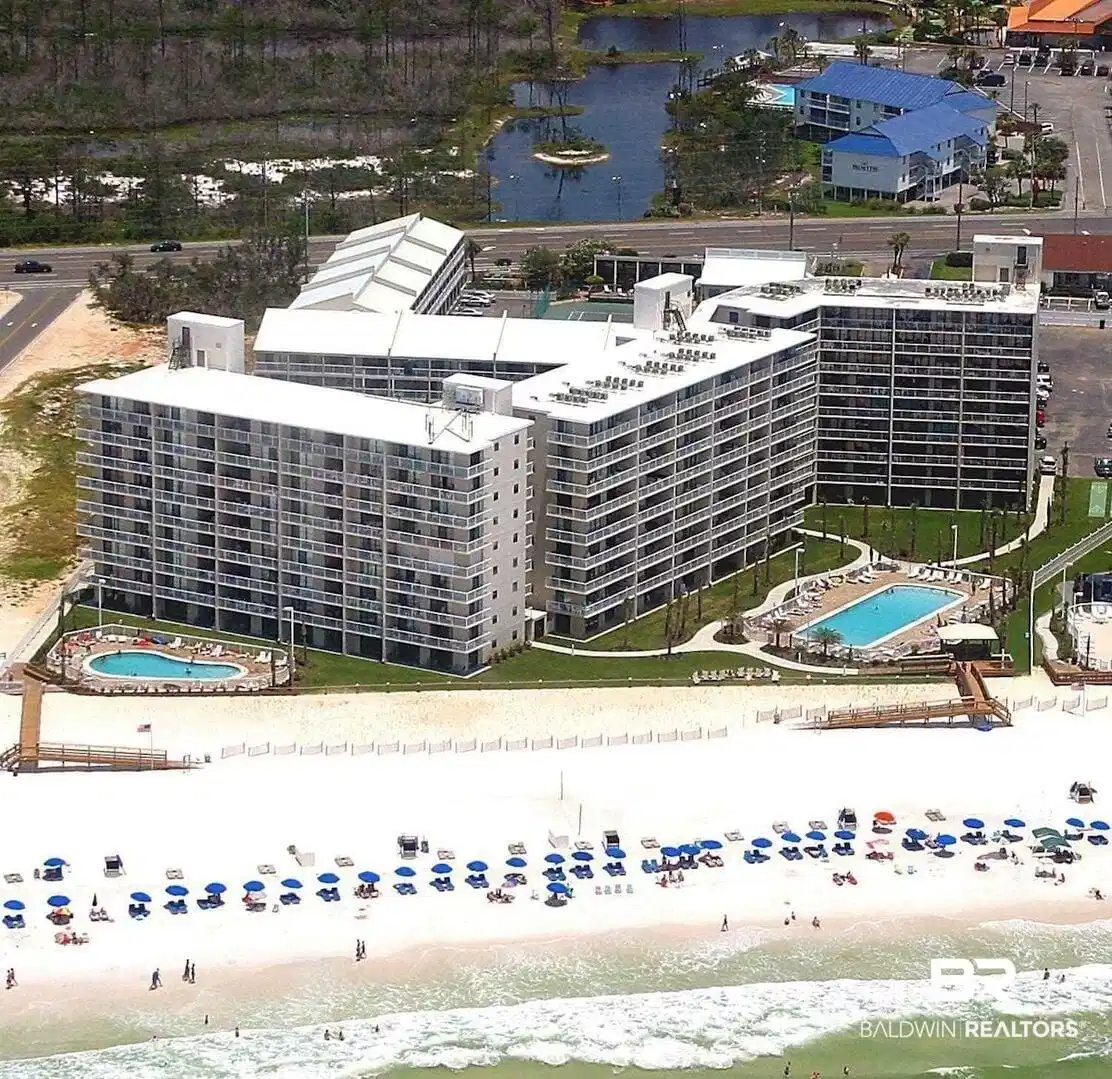 Image 1: Multi-story condominium buildings fronting a white sand beach