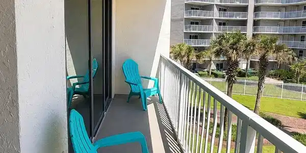 Image 4: Private balcony featuring a painted concrete floor, white exterior wall with a wall-mounted light fixture, and a white metal railing