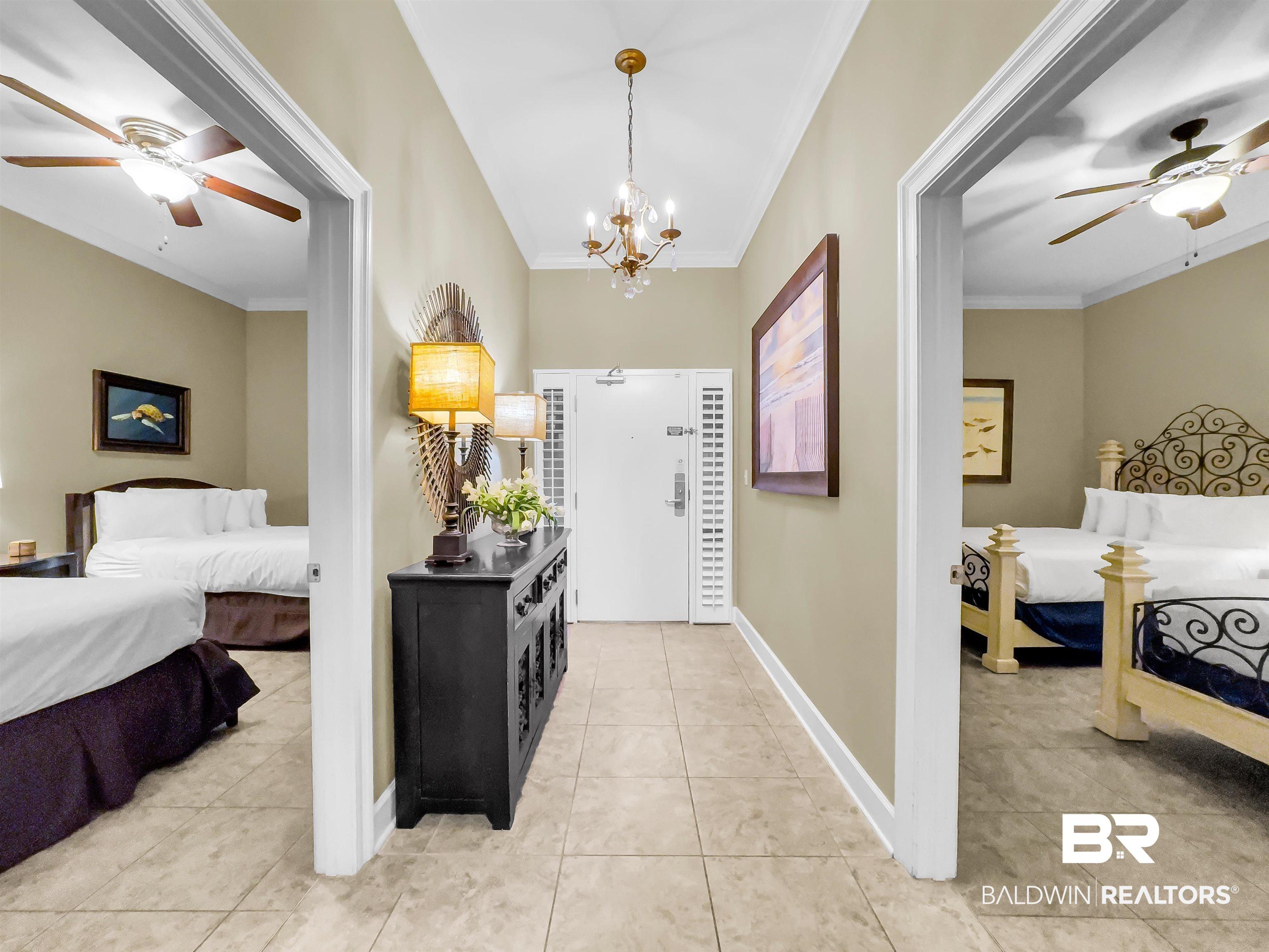 Image 2: Foyer with a ceiling fan, crown molding, light tile patterned flooring, and a chandelier