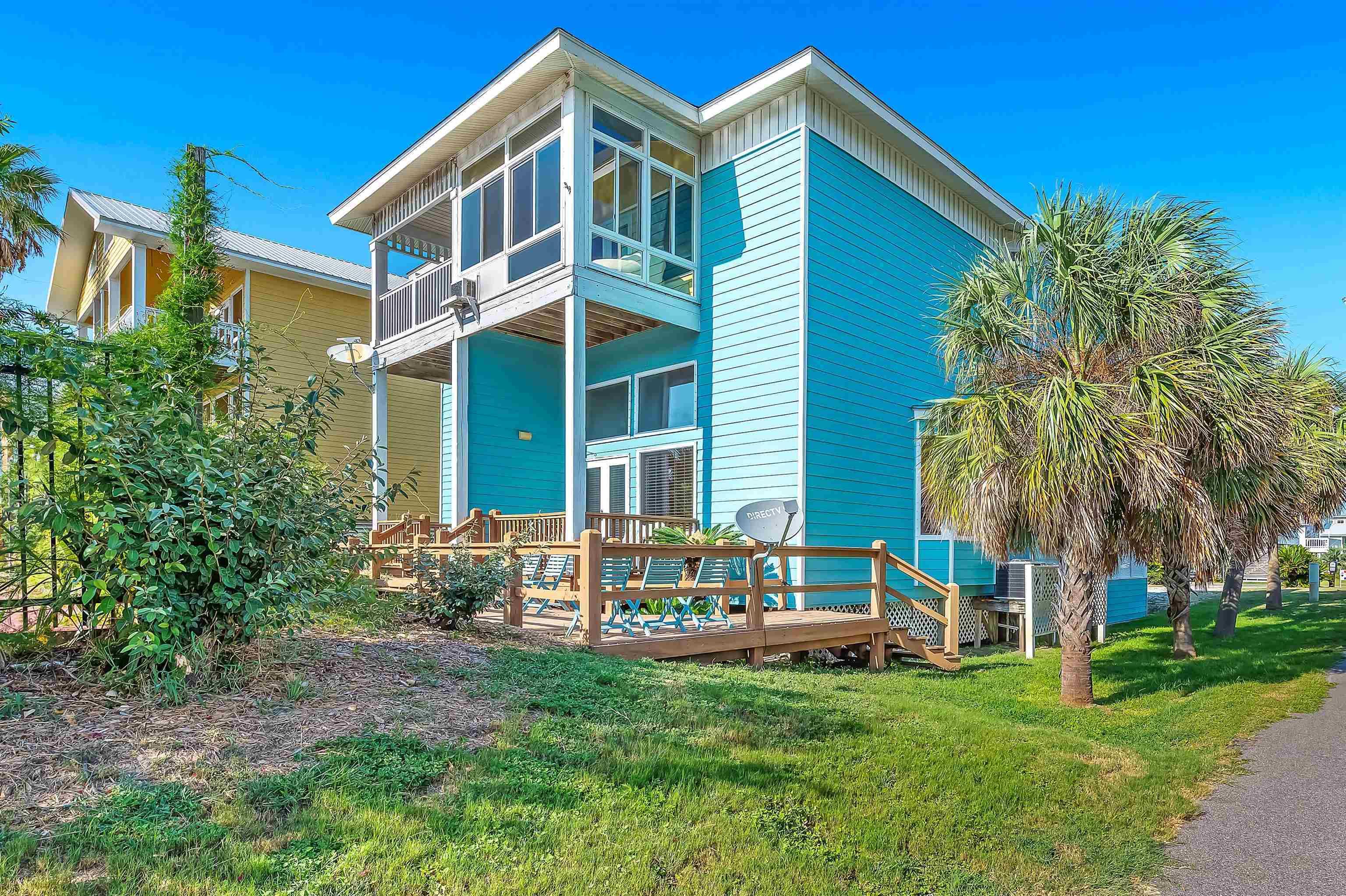 Image 2: Rear view of house with a lawn, a wooden deck, and a balcony