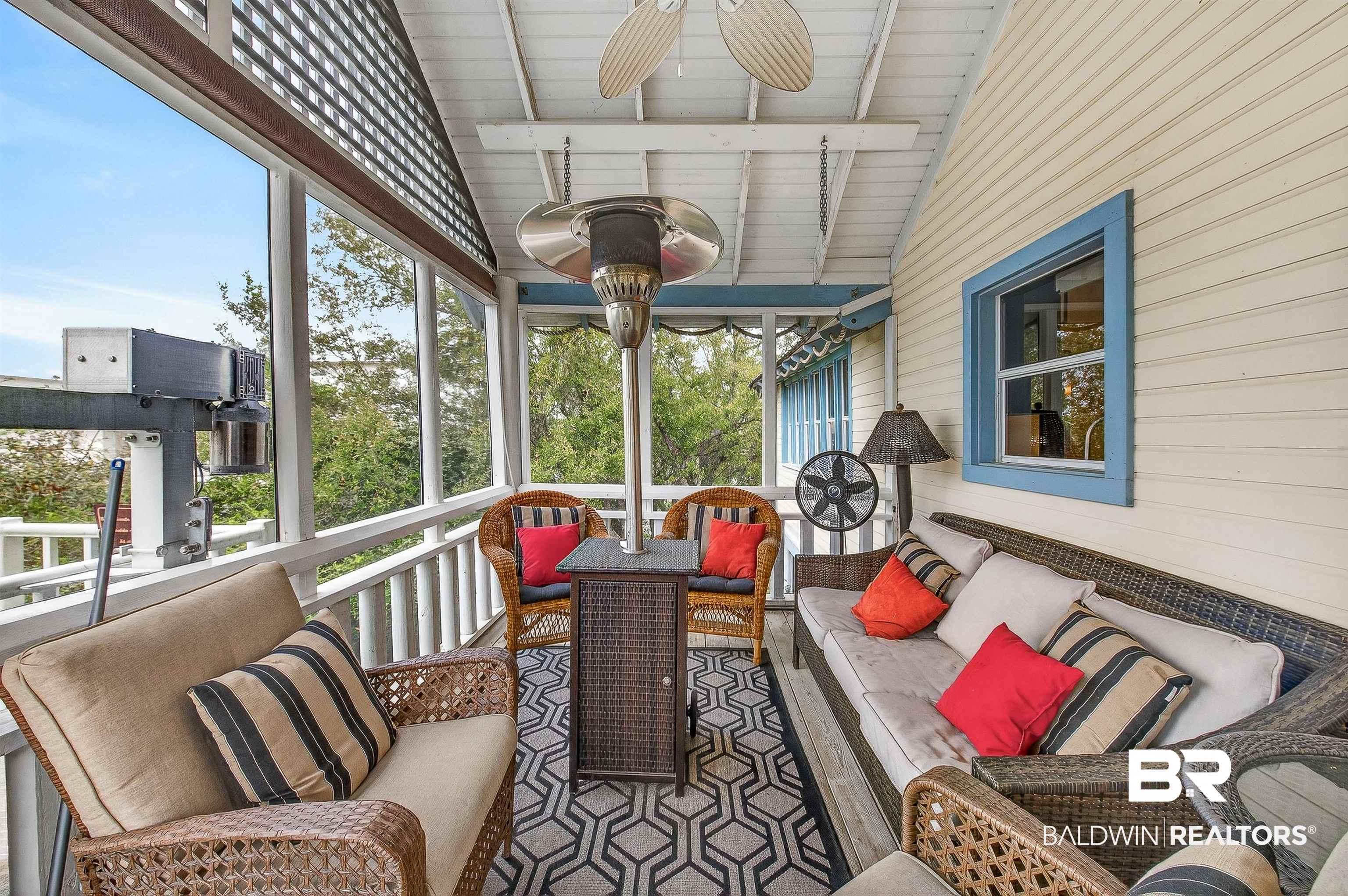Image 3: Sunroom with outdoor furniture, a ceiling fan, plenty of natural light, and lofted ceiling with beams