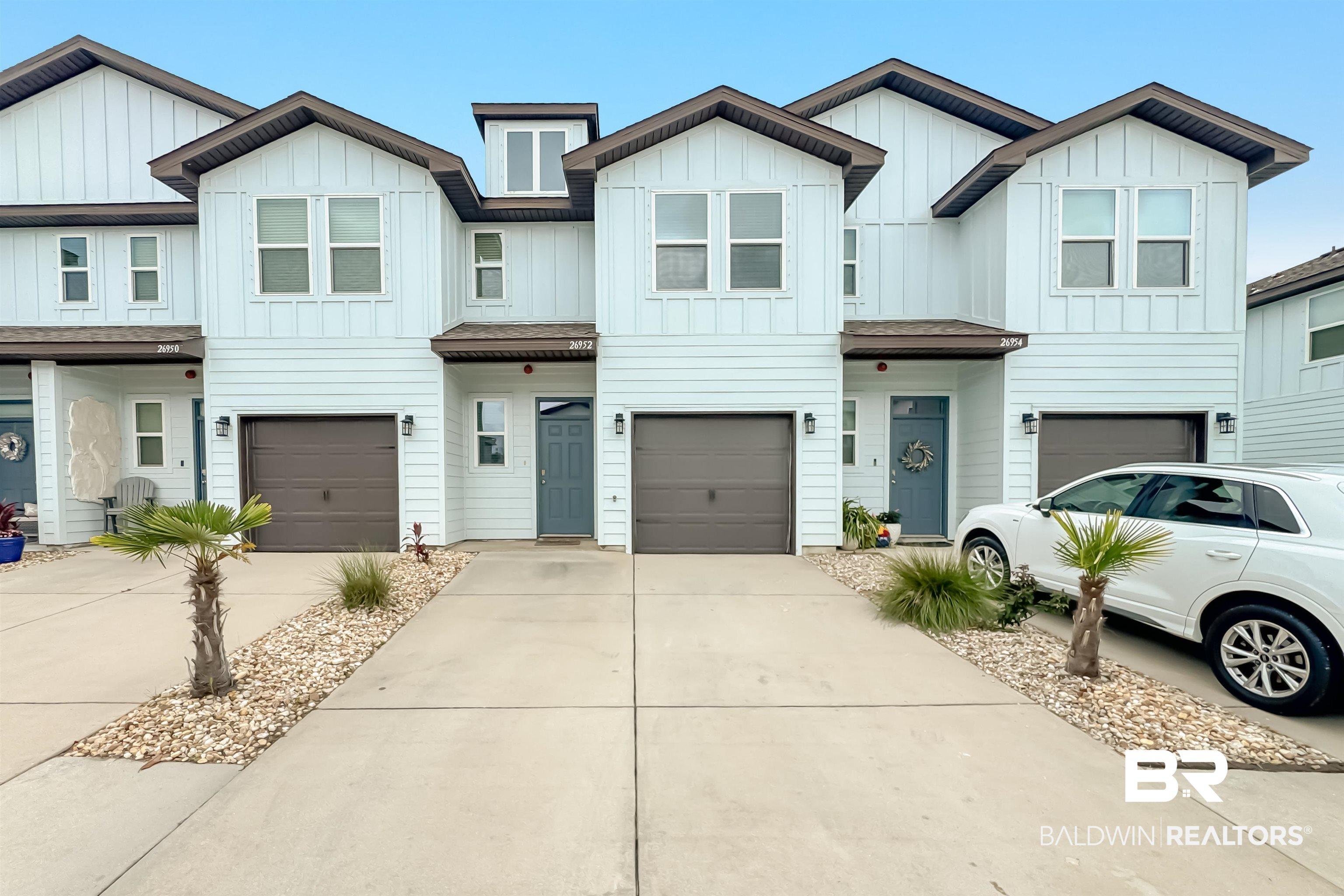 Image 1: Contemporary townhome exterior featuring light-colored horizontal siding and dark brown trim accents